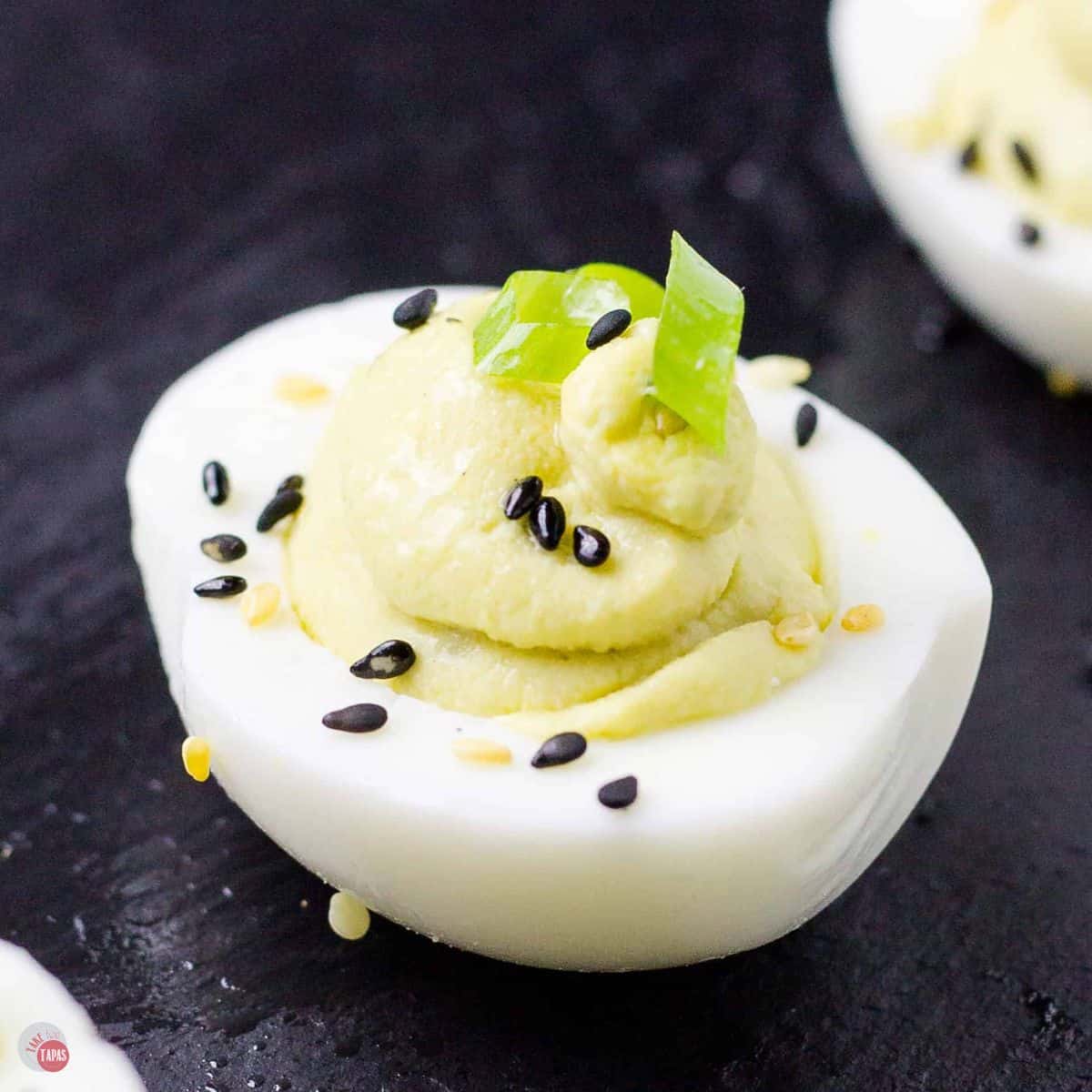 wasabi deviled egg on a black slate platter