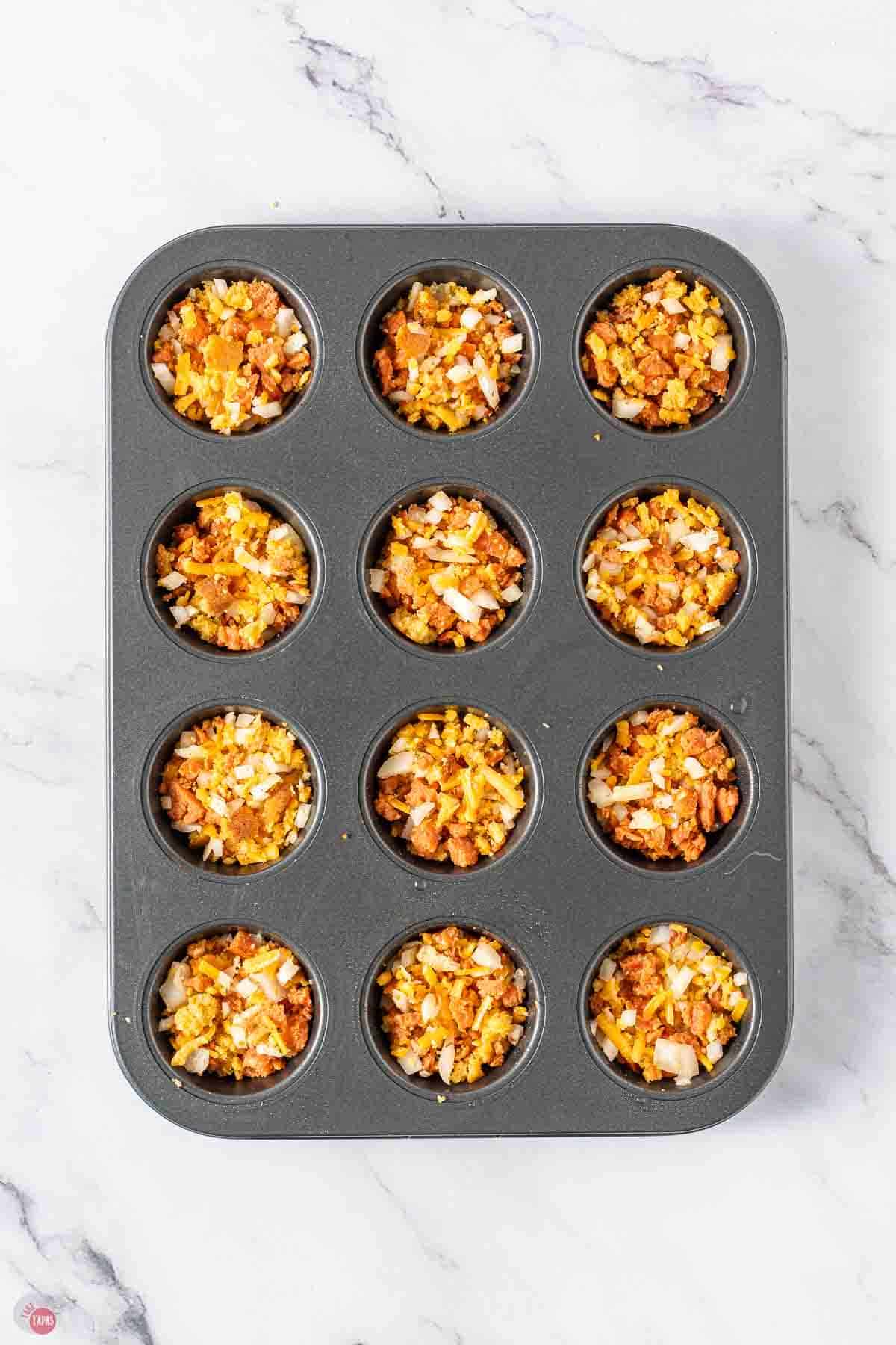 mini muffin pan with sausage cornbread mix in each one