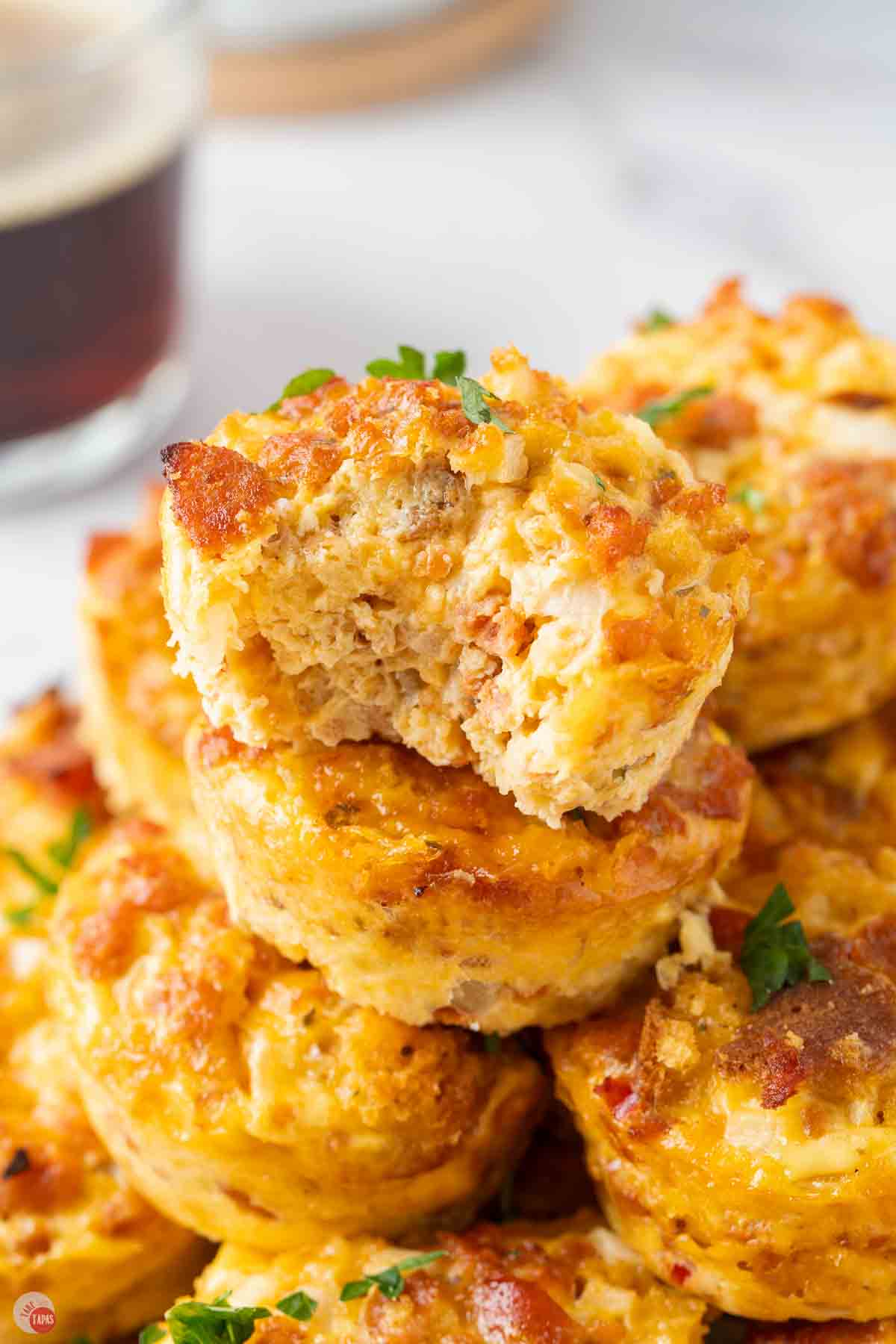 stack of breakfast casserole muffins with a bite taken out of the top one