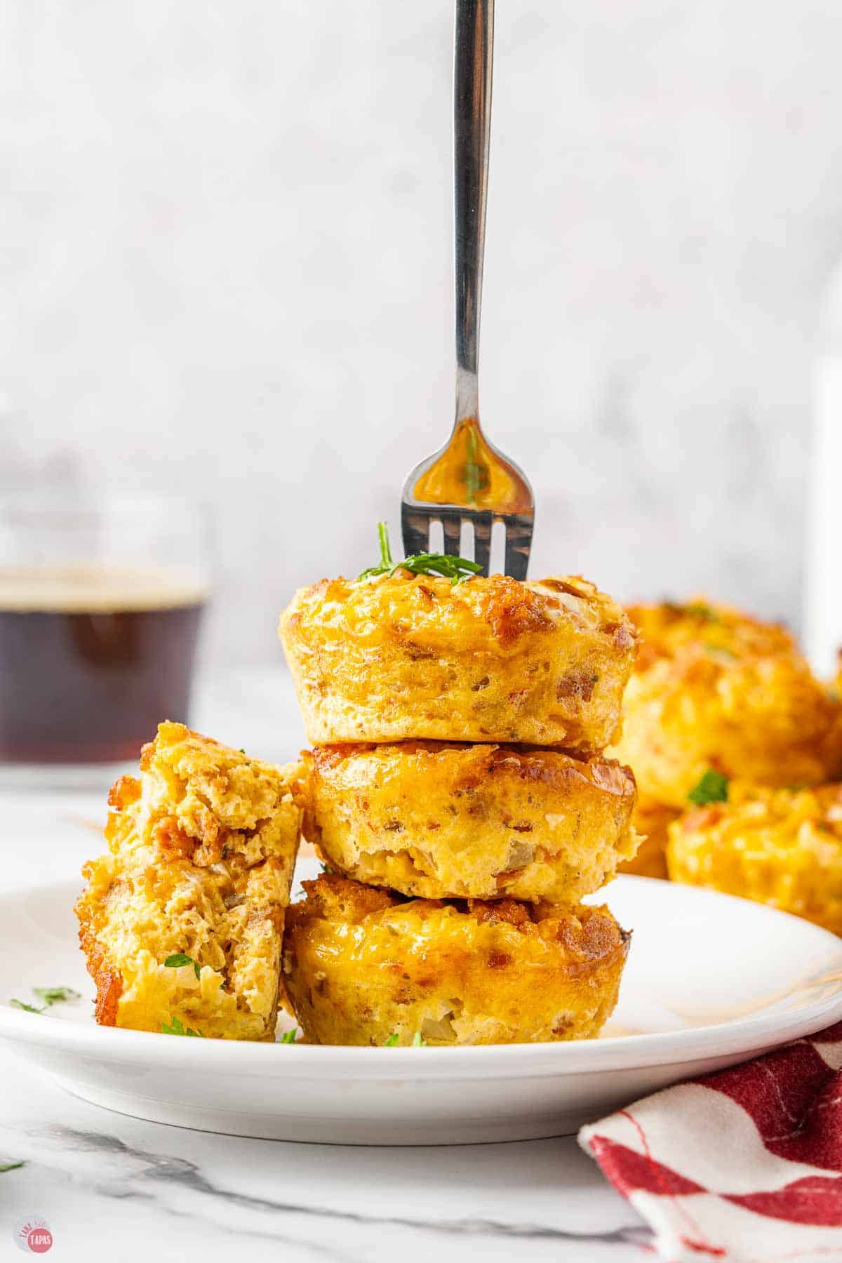 stack of breakfast casserole bites on a plate with a fork in them