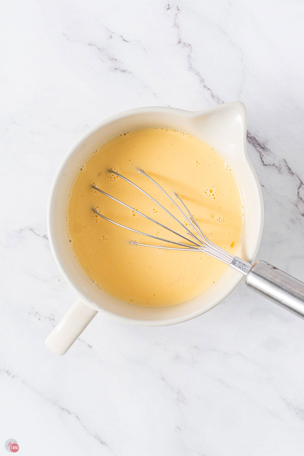white mixing bowl with egg and milk mixture