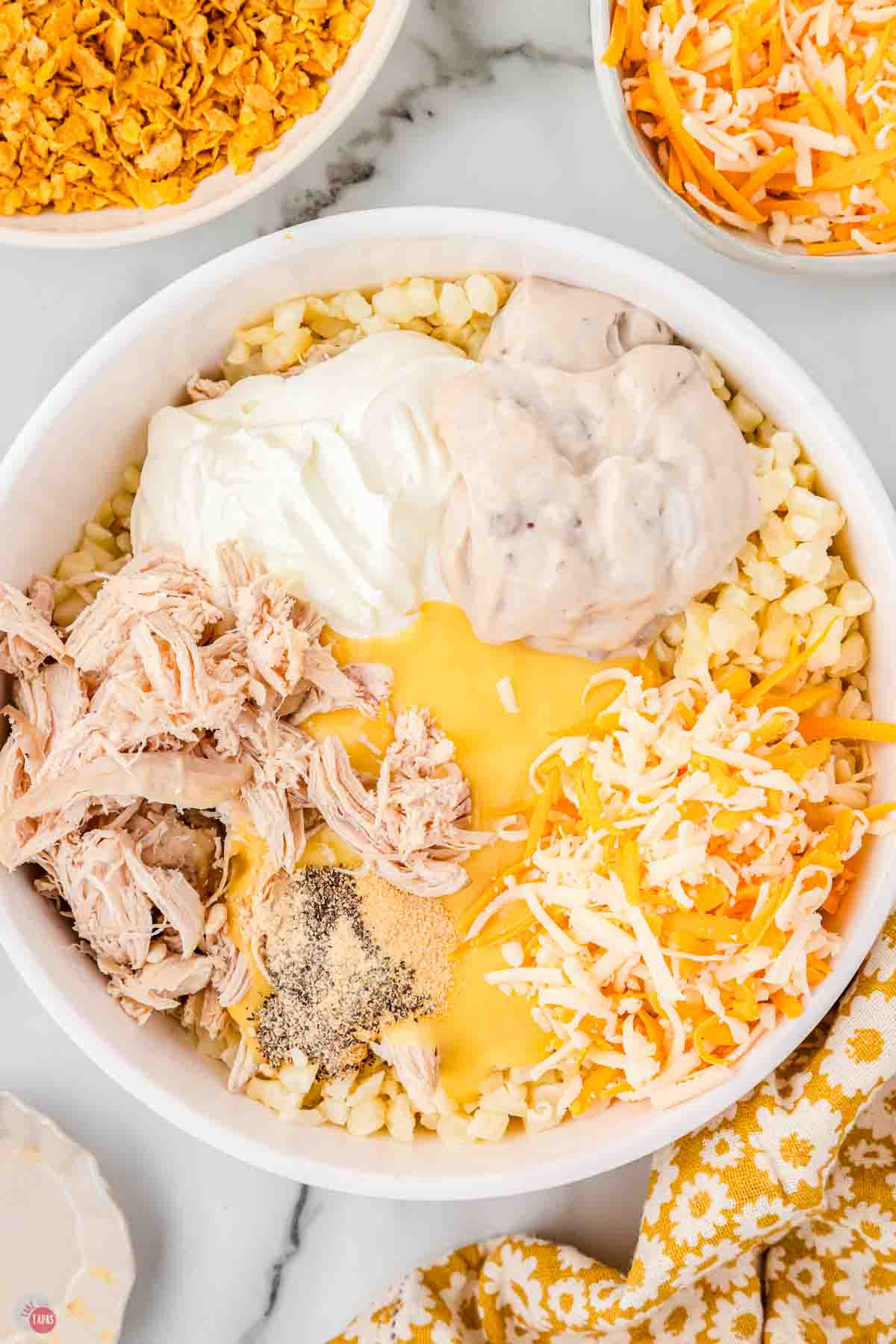 white mixing bowl with chicken, soup, cheese, and sour cream