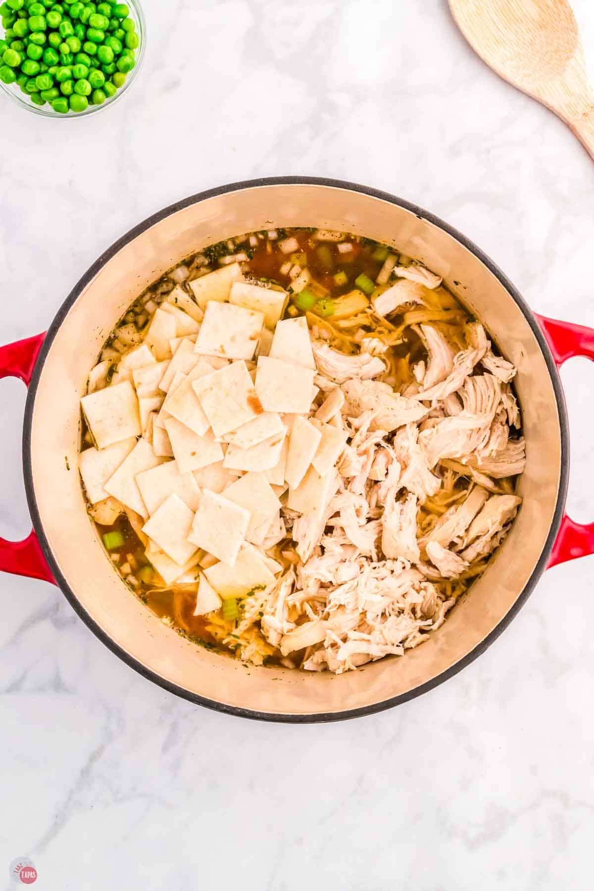 red pot with chicken and sliced tortillas