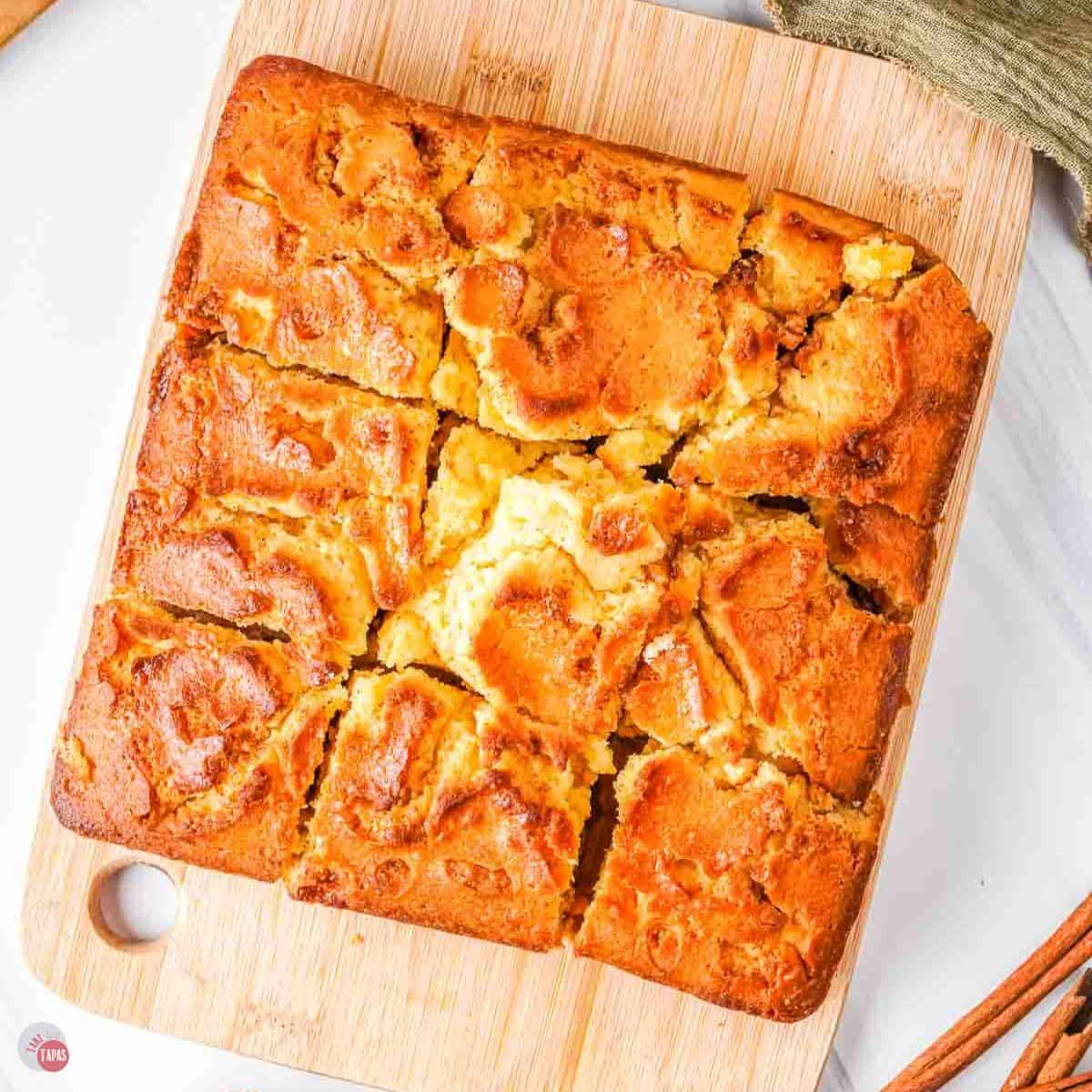 wood board with a square cake on it, cut into 9 squares