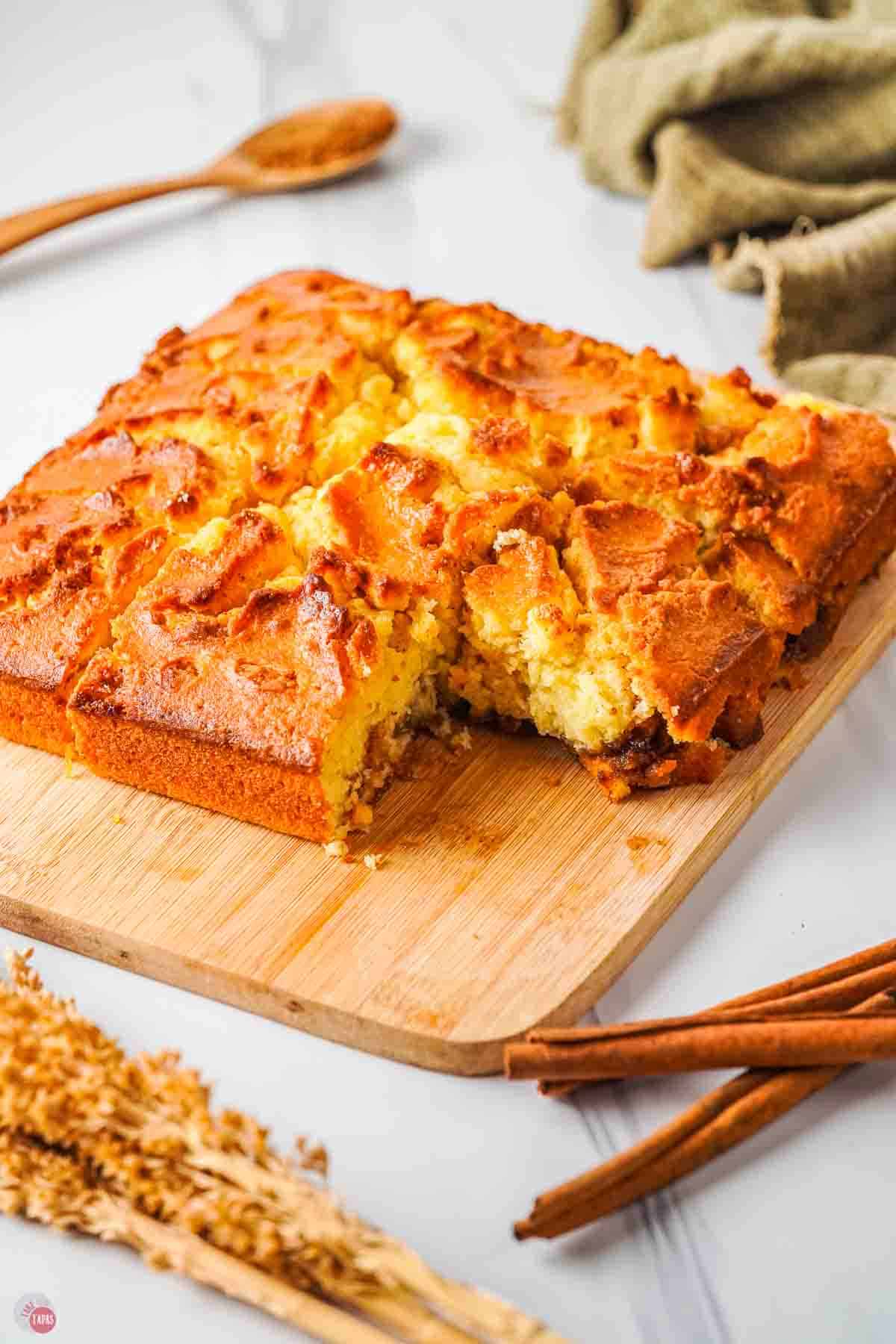 cinnamon flop cake on a wood board with a piece cut off