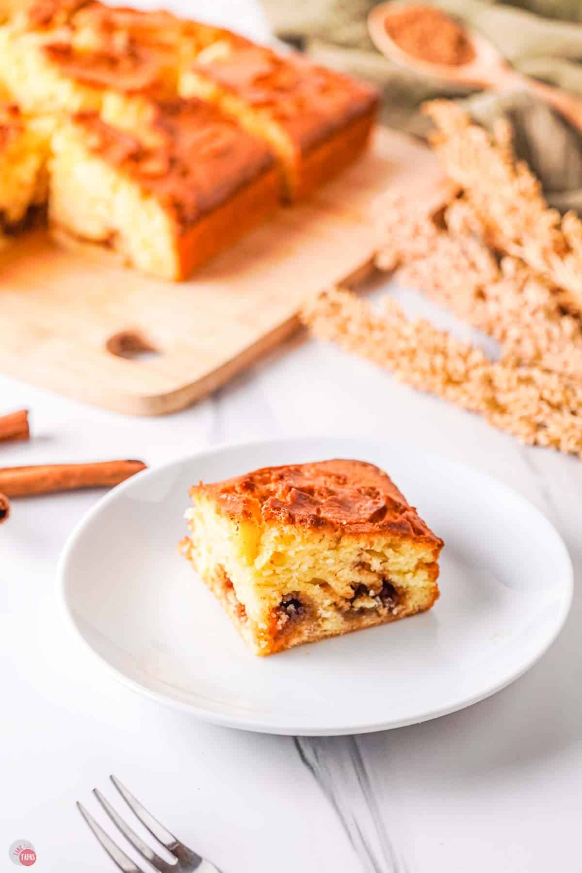 white plate with slice of cinnamon cake on it