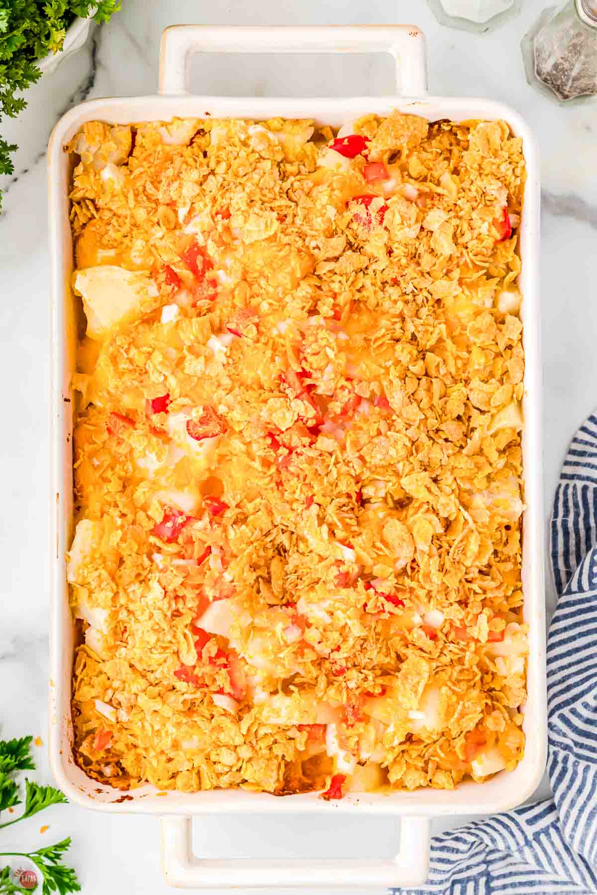 white casserole dish full of cottage potatoes topped with cornflakes
