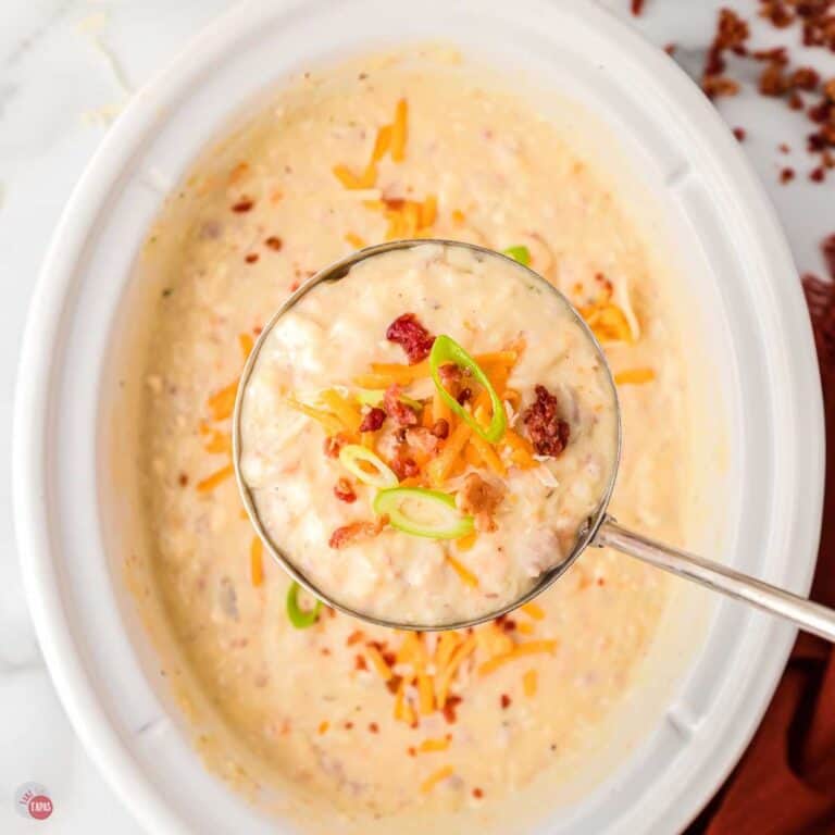 white crockpot full of potato soup and a ladle