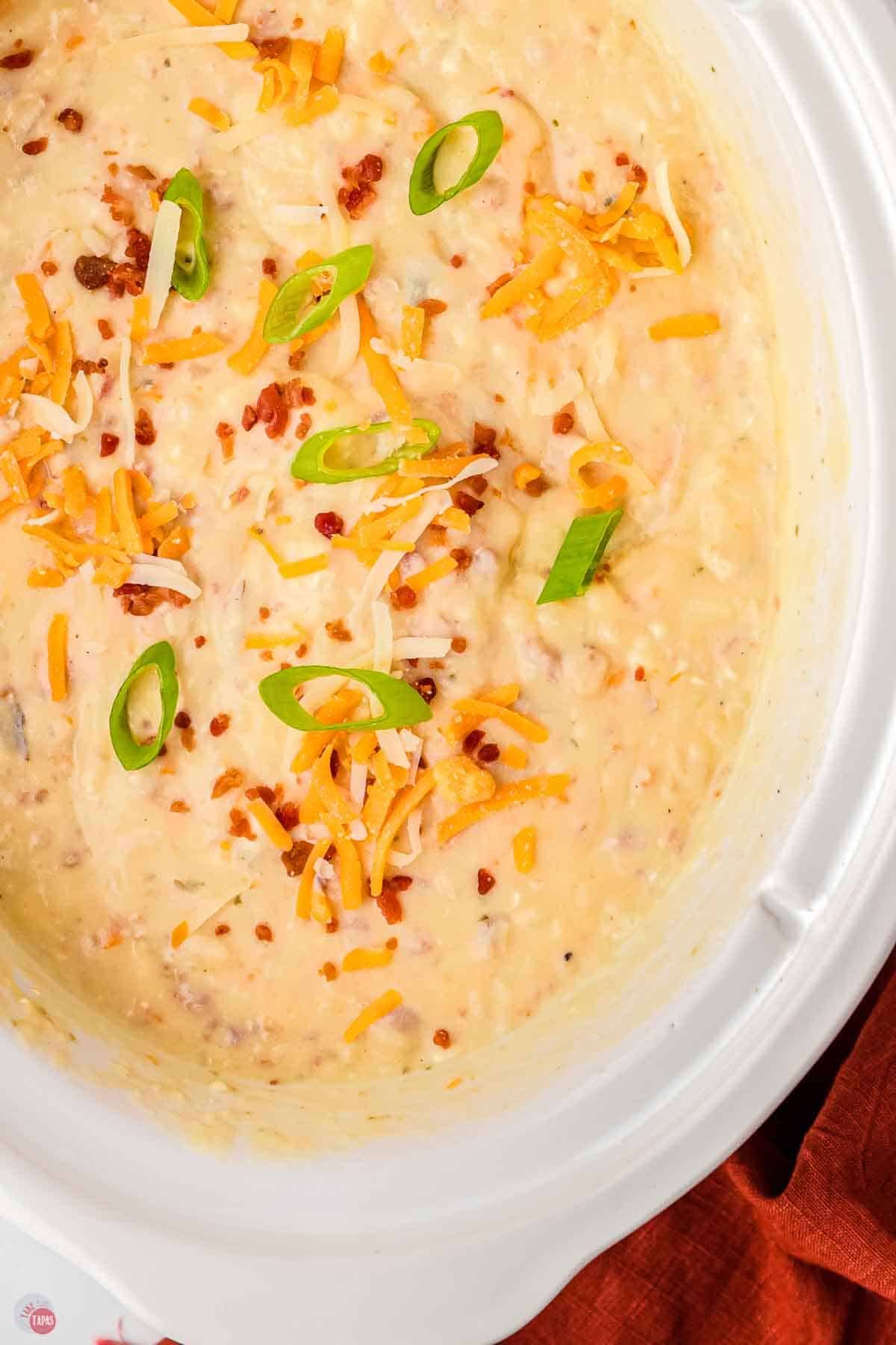 close up of loaded potato soup in a white crock pot