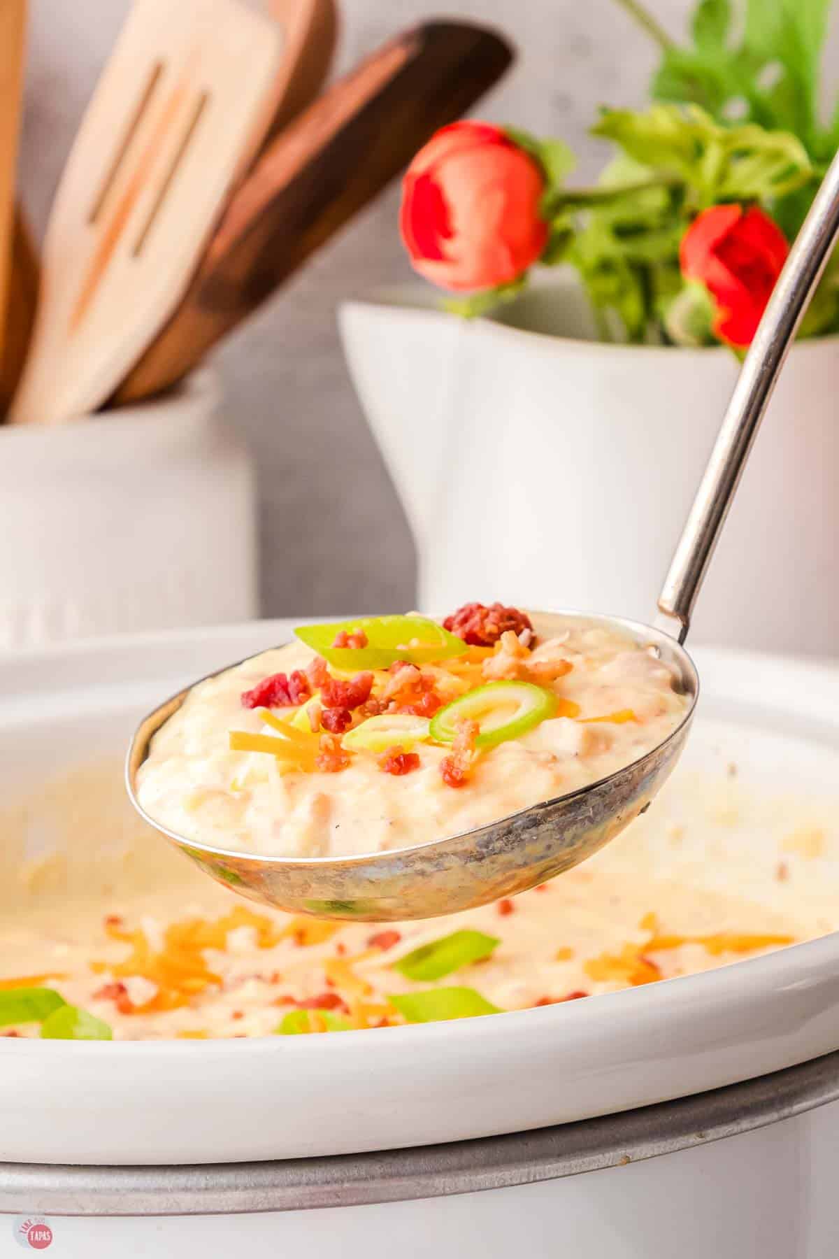 side view of soup ladle filled with potato soup