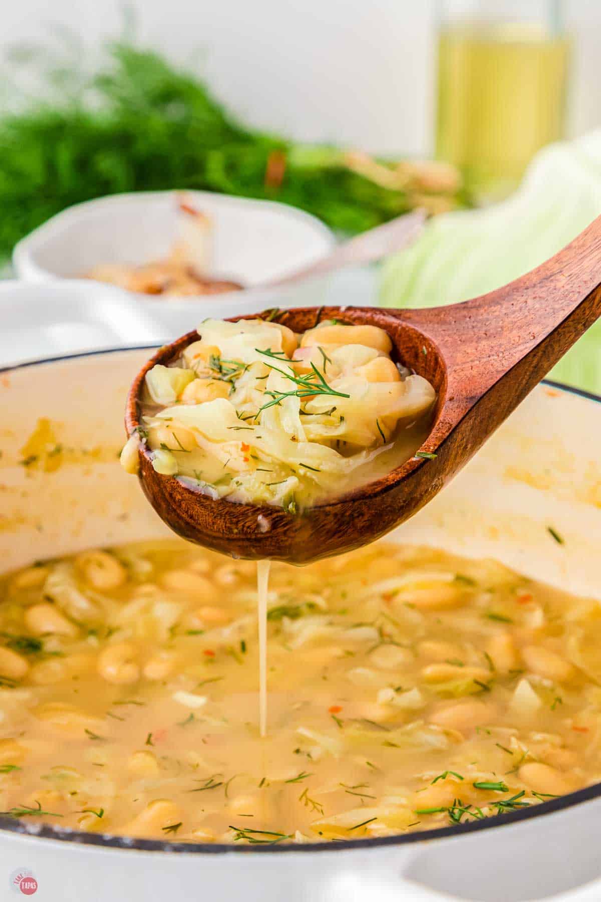 wood spoon scooping soup out of a pot
