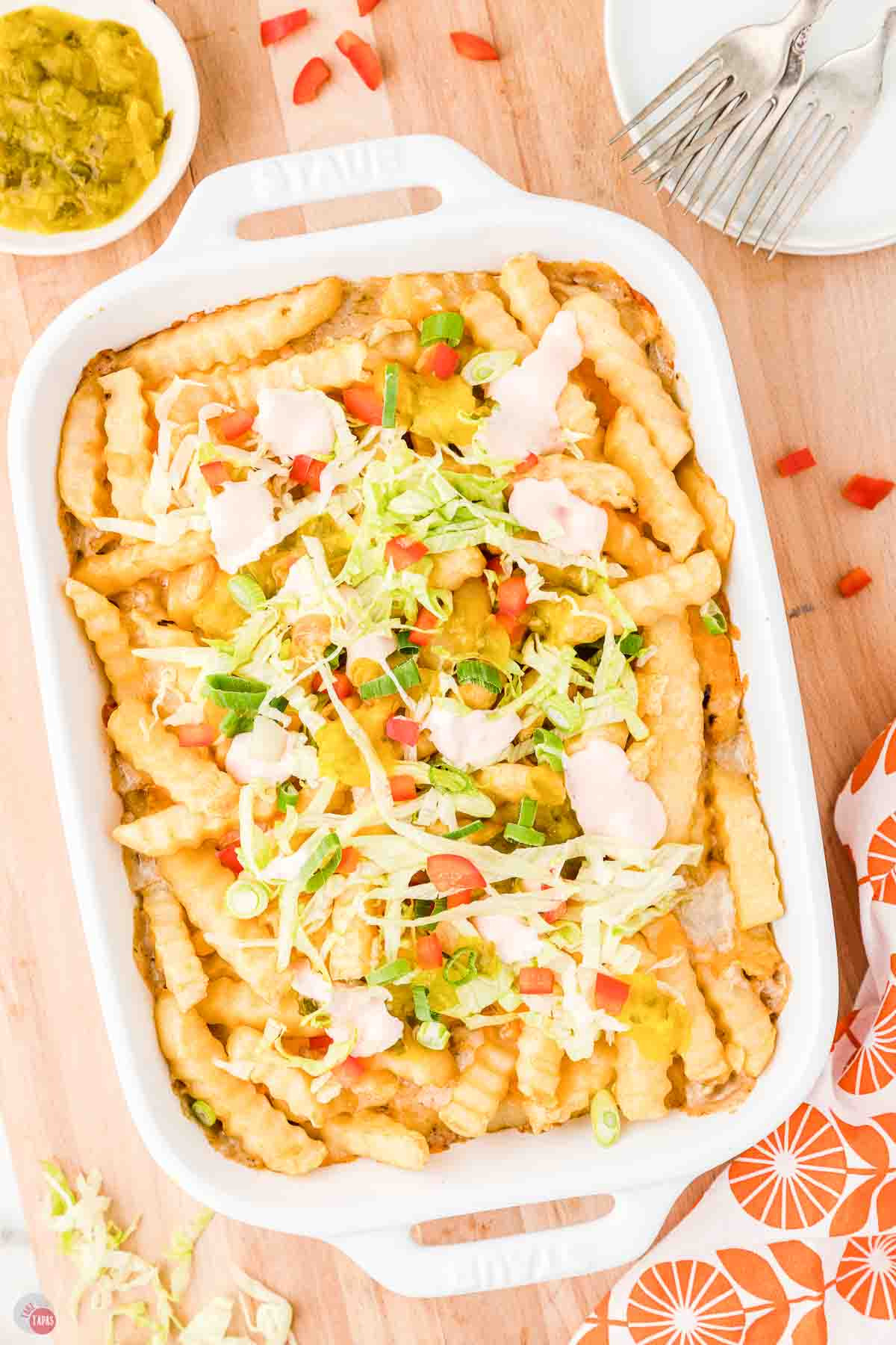 baked french fry casserole topped with shredded lettuce, tomatoes, and sauce