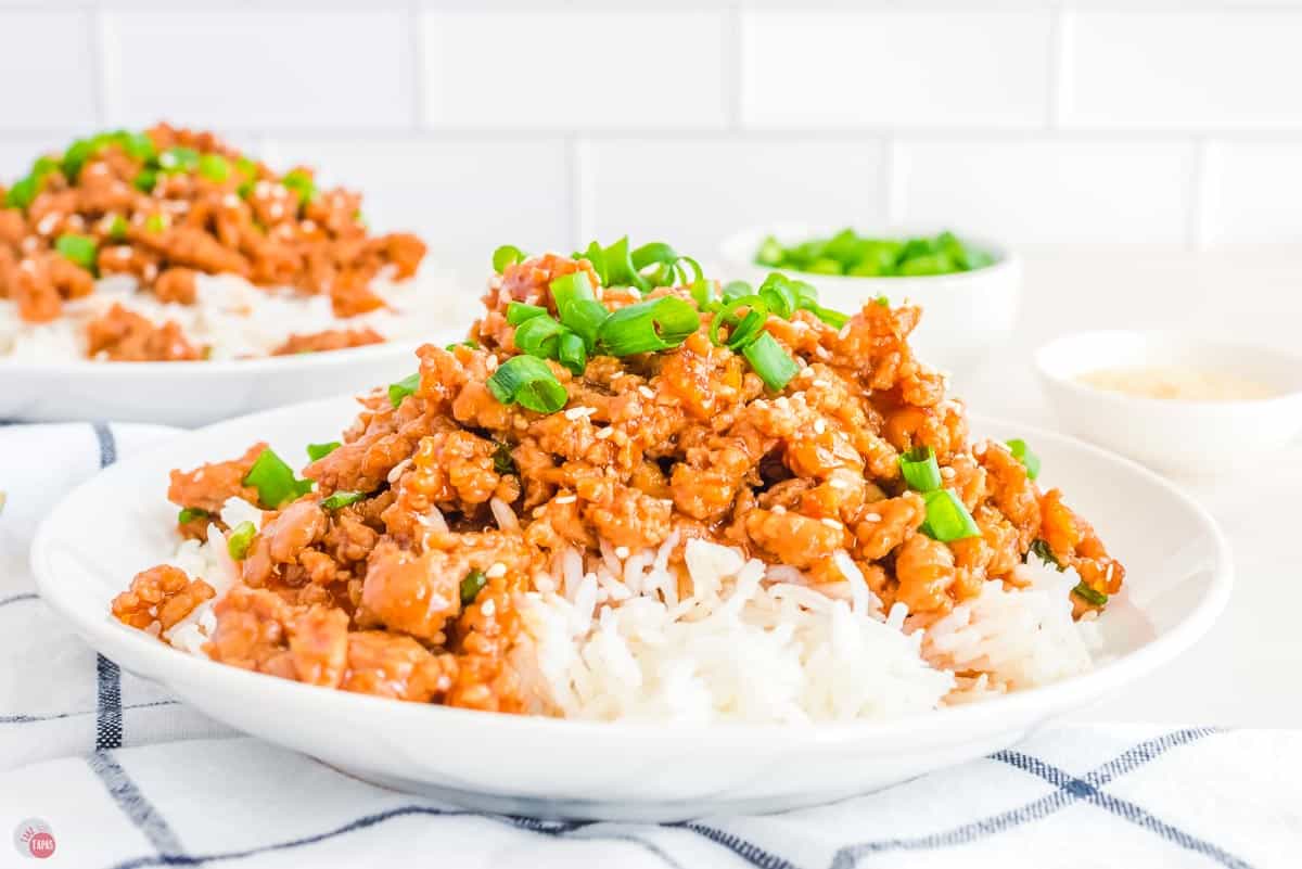 plate of rice topped with ground orange chicken