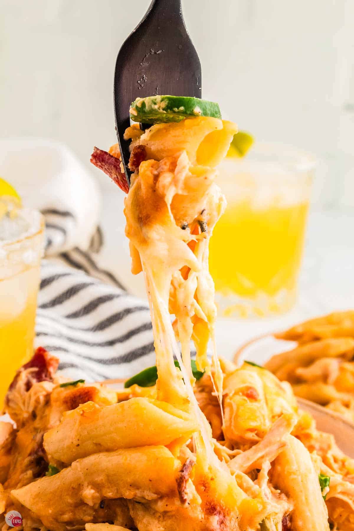 fork with bite of pasta, cheese, and chicken