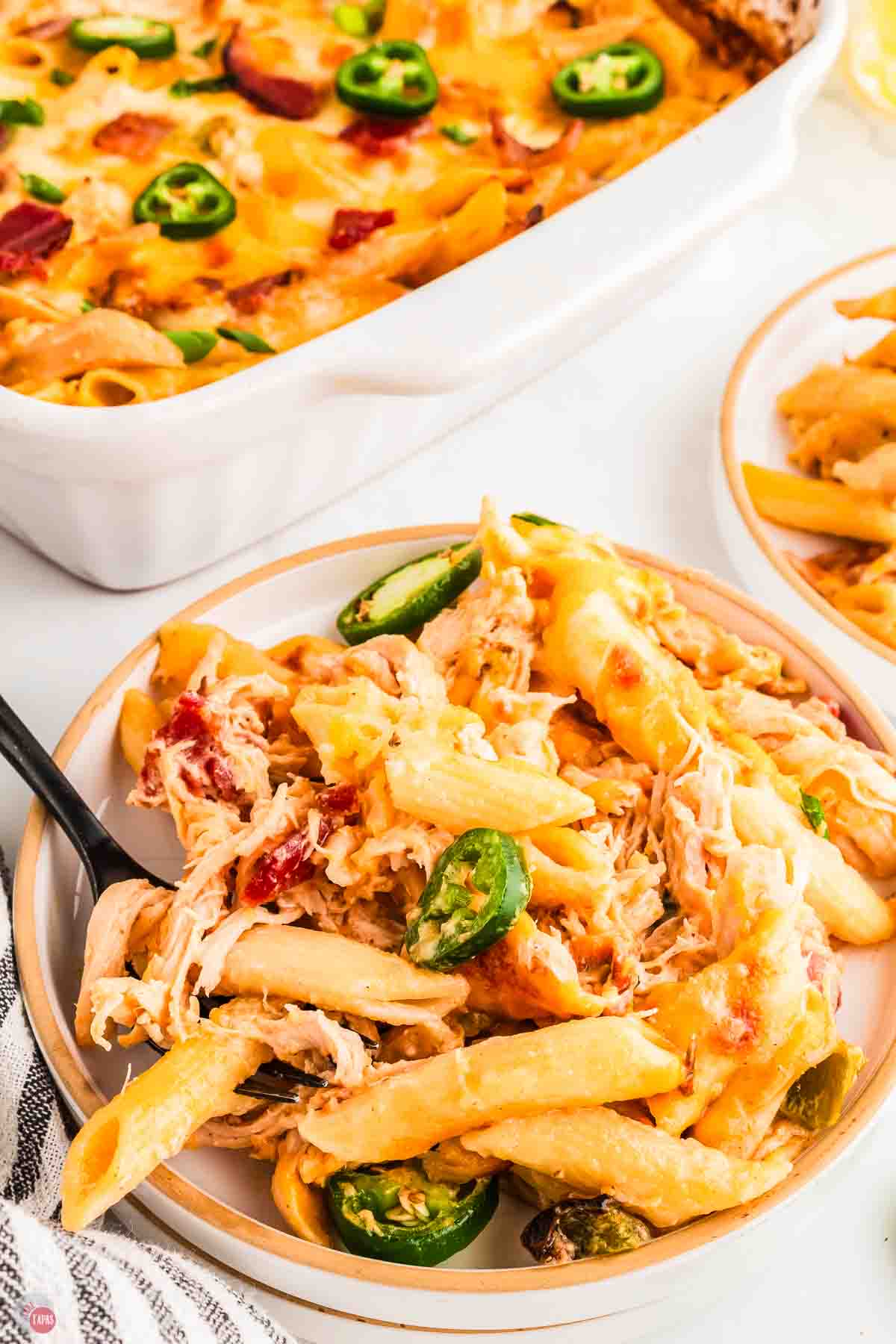 plate with portion of pasta casserole with a fork stabbing a bite