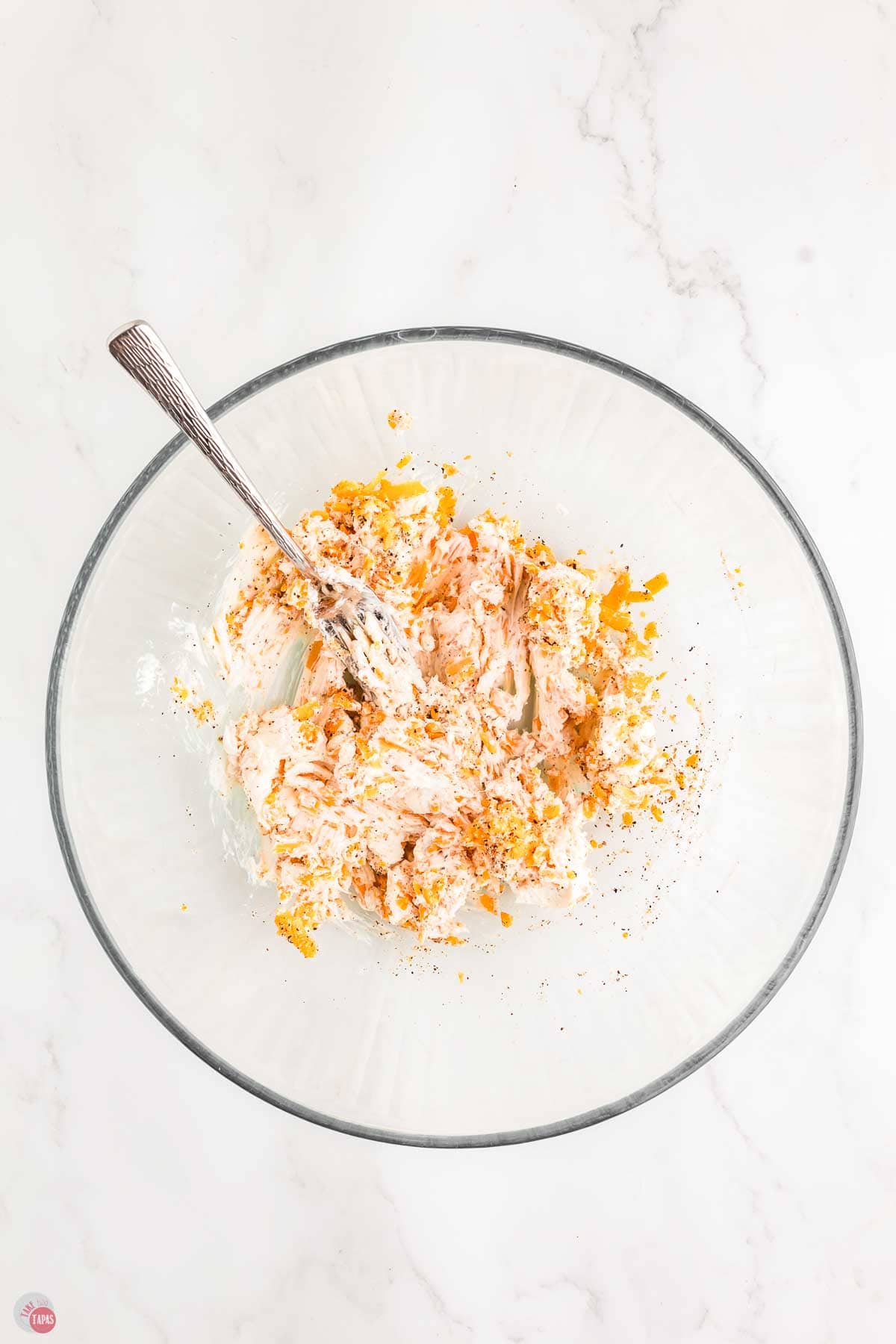 shredded chicken, cream cheese, and shredded cheese in a clear bowl