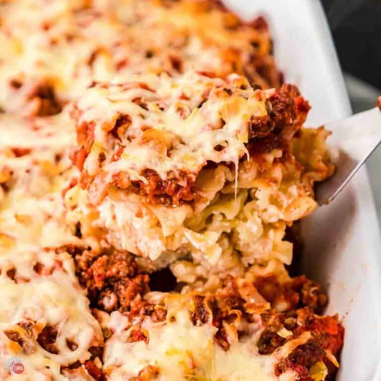 scoop of pasta casserole on a metal spatula over a dish
