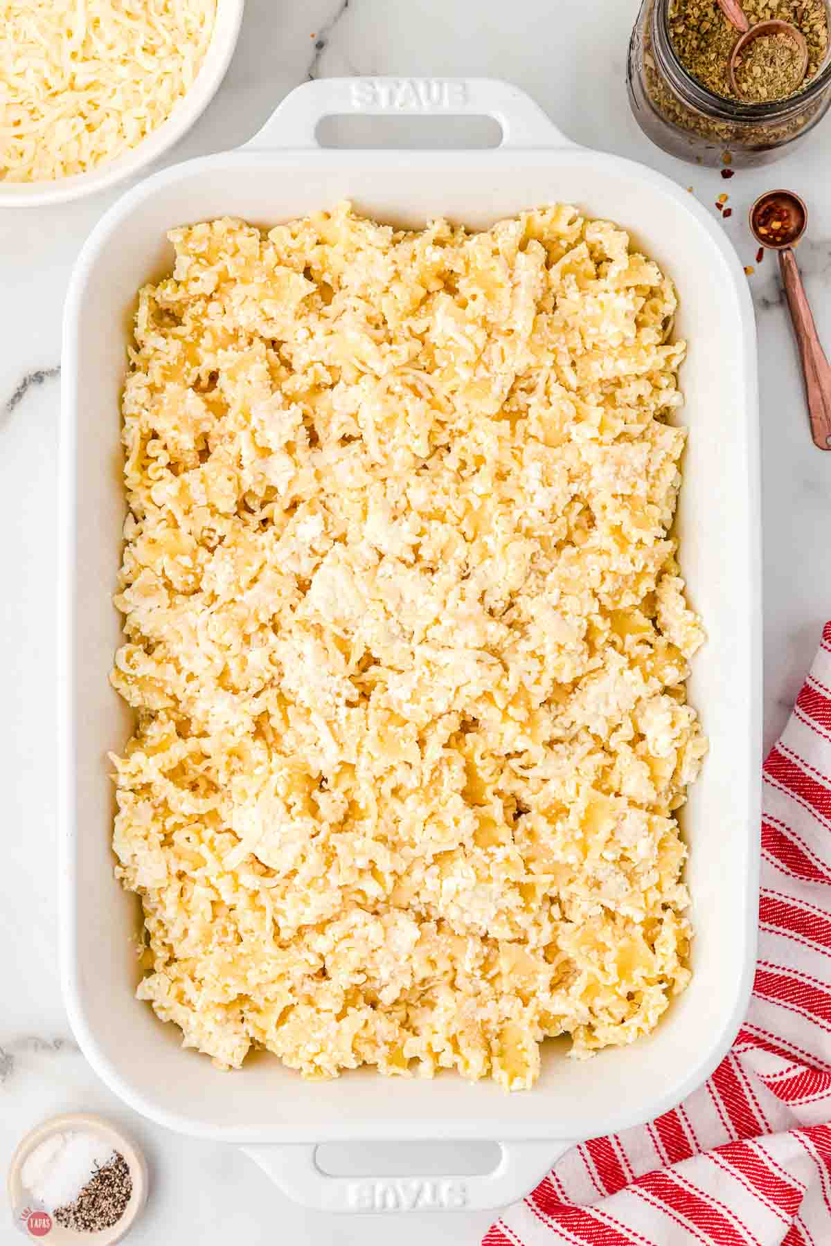 pasta noodles mixed with cheese sauce in a 9x13 casserole dish