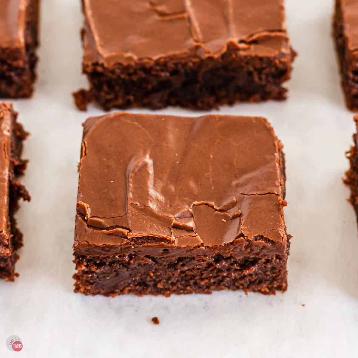lunch lady brownie next to others on a piece of parchment paper