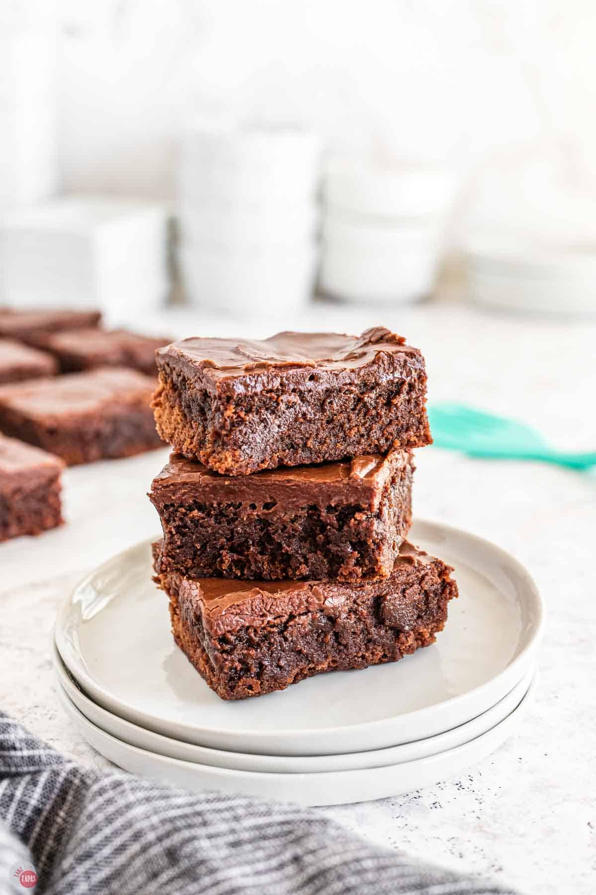 stack of brownies on a small stack of white plates