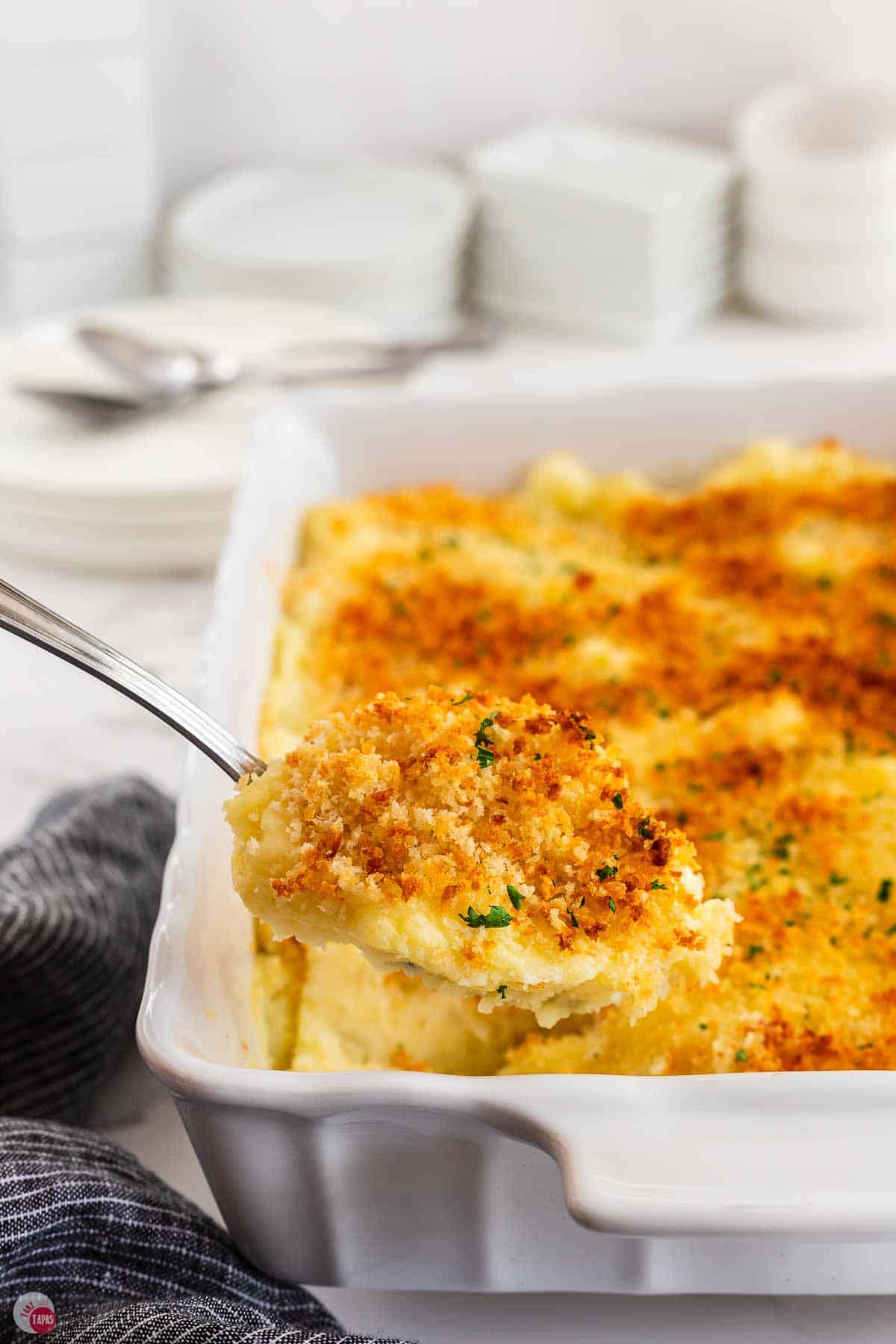 scoop of mashed potato casserole over a baking dish