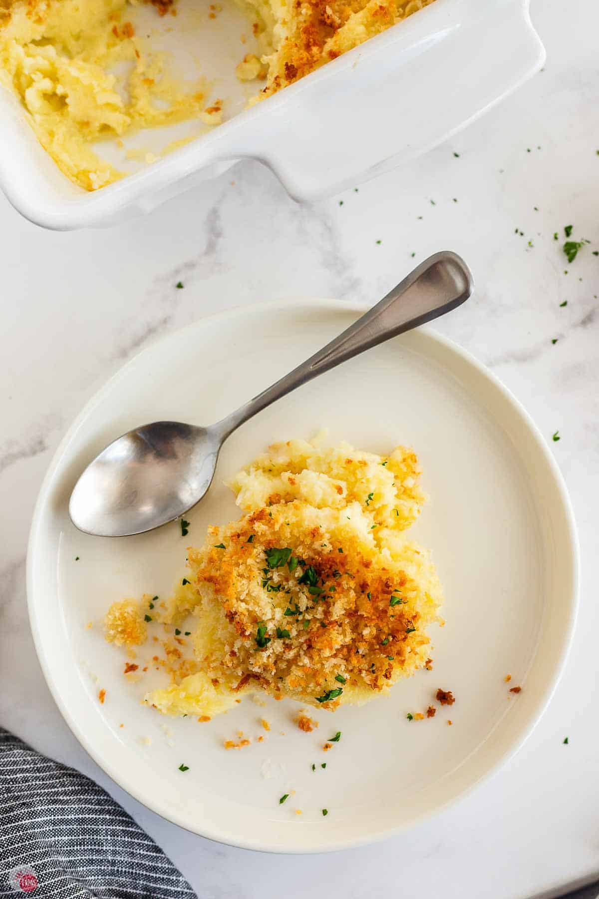 scoop of mashed potato gratin on a plate with a spoon