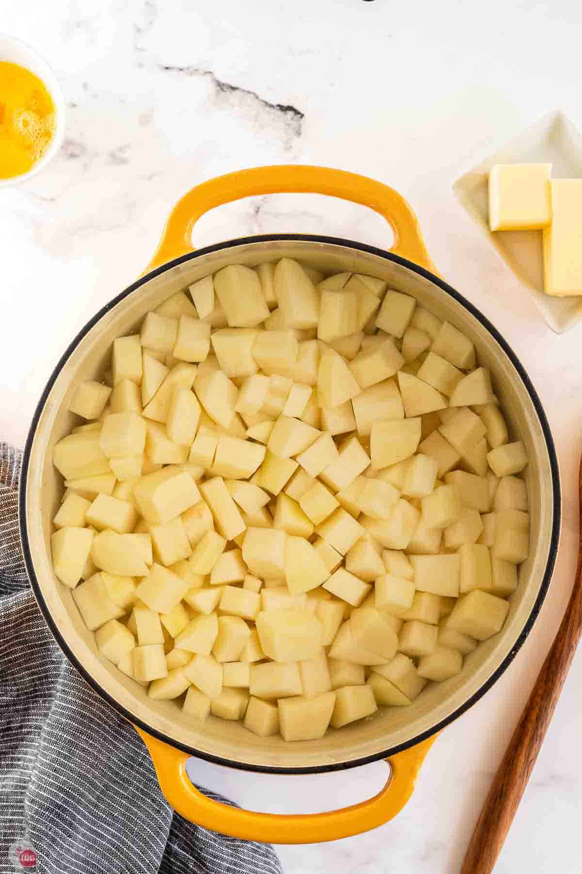 diced potatoes cooking in a large yellow pot