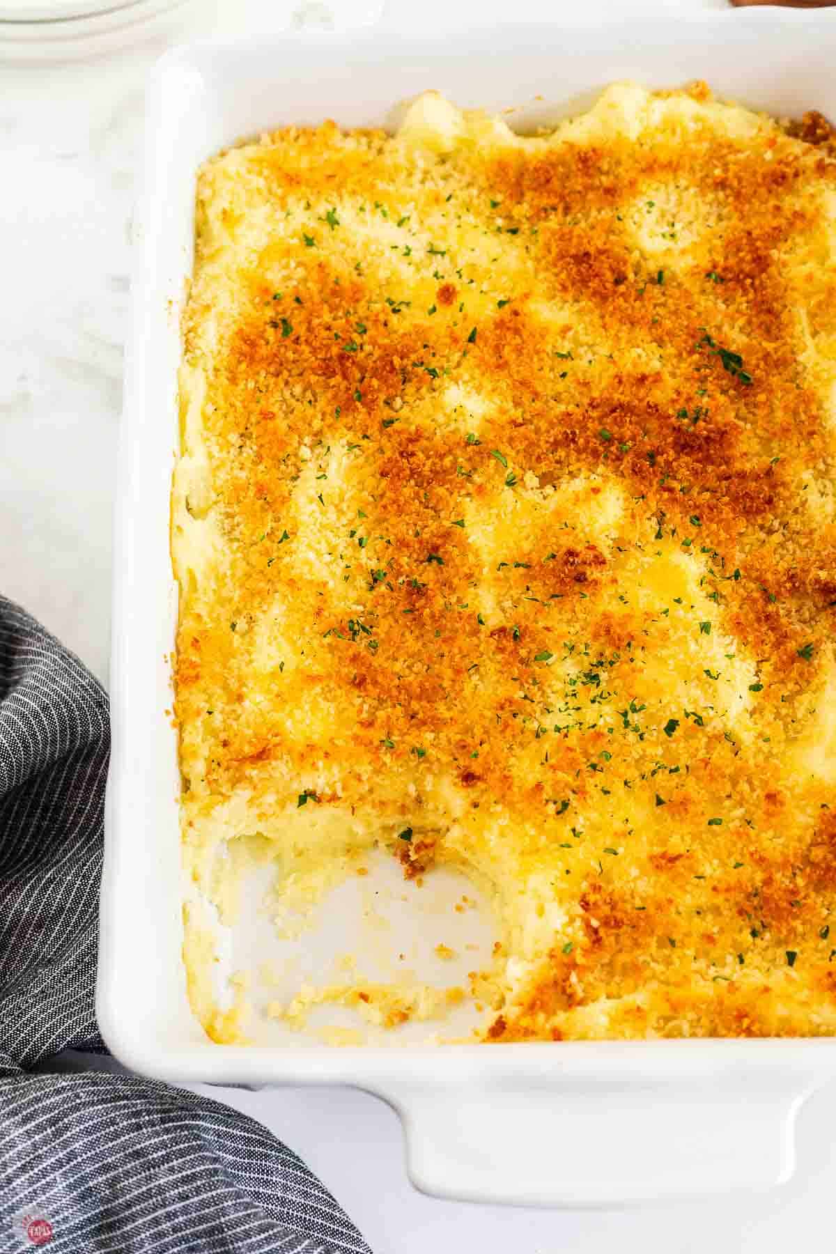white casserole dish with a scoop of the recipe missing