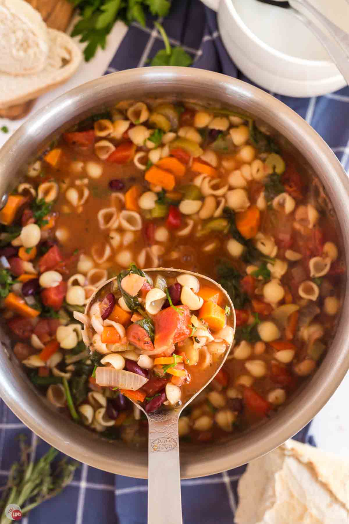 pot of minestrone soup with a ladle scooping out some