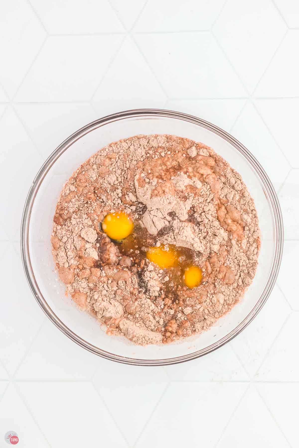 clear mixing bowl with cake mix powder, oil, water, and eggs in it, unmixed