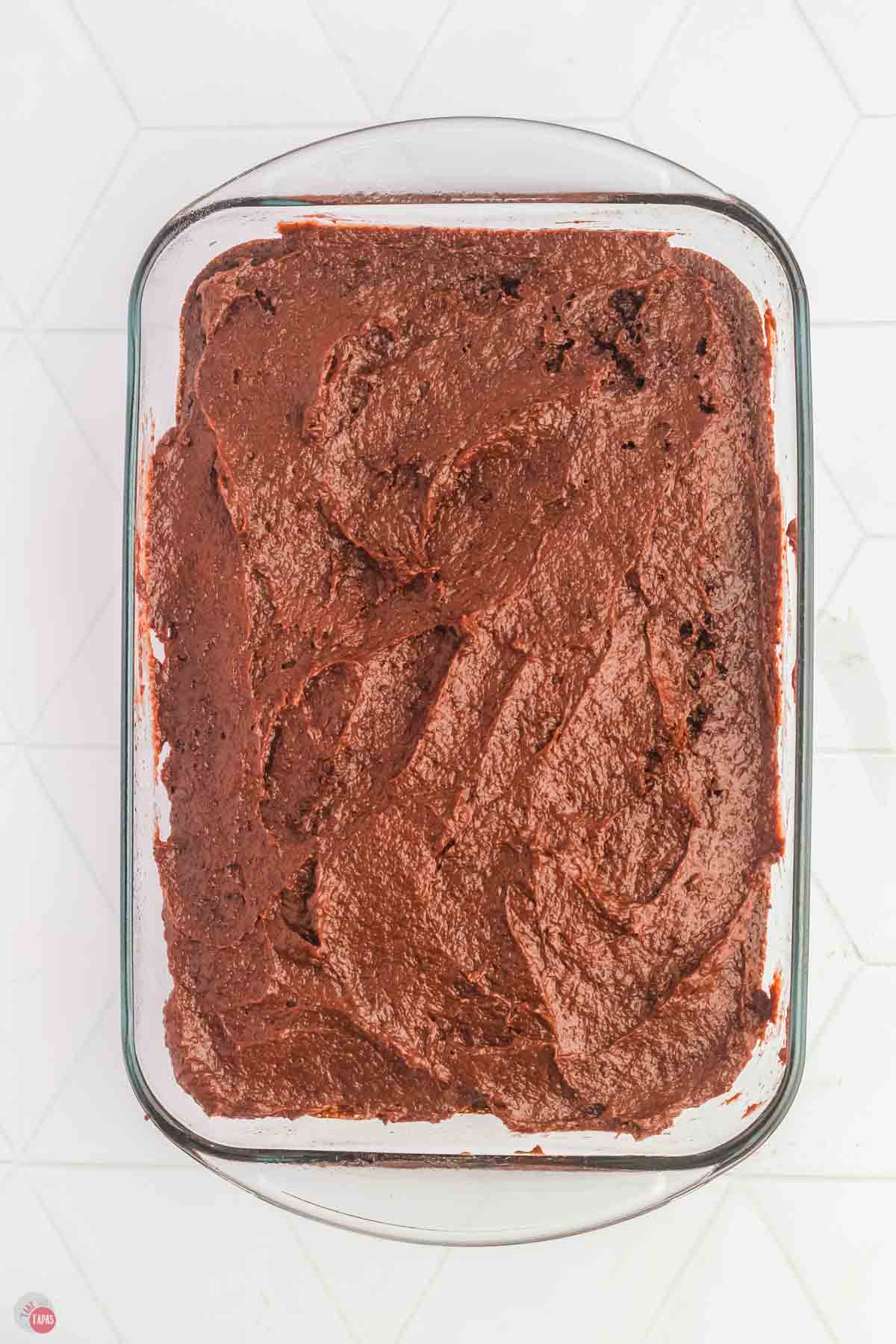 chocolate cake in a rectangle dish topped with a creamy chocolate pudding frosting