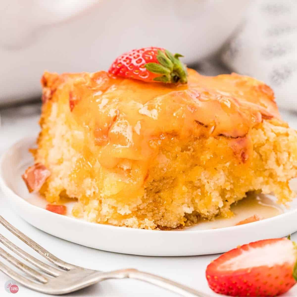 slices of pancake casserole on a white plate and topped with syrup and sliced strawberries