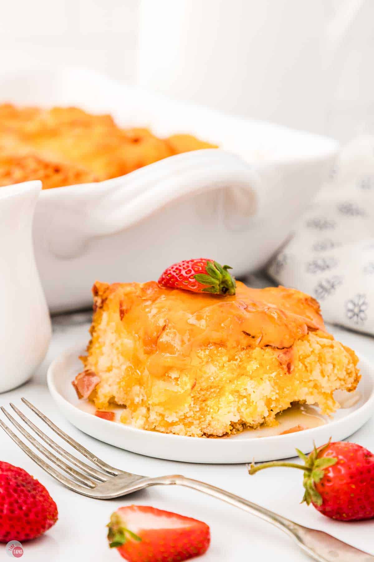 slice of casserole on a plate with strawberries around it