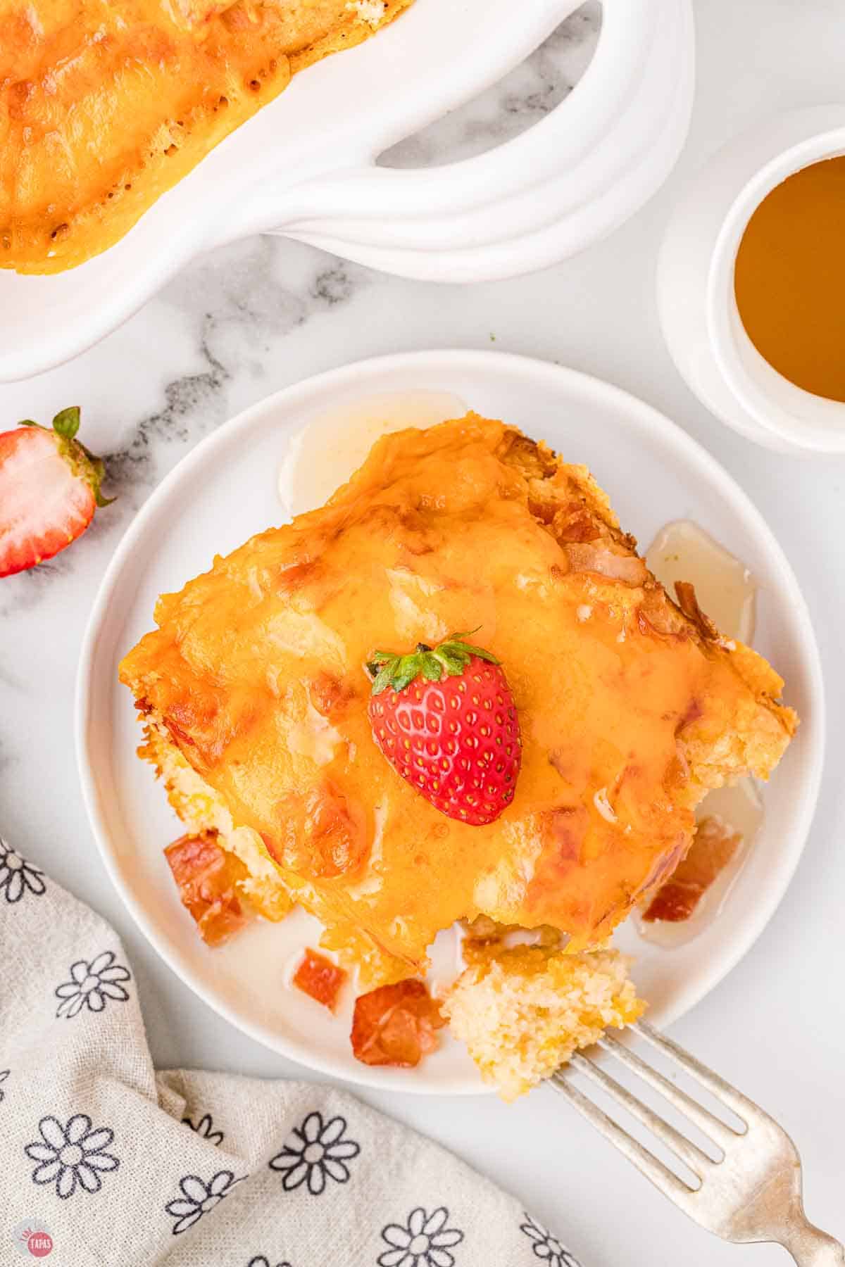 plate of pancake bacon casserole with strawberries and syrup