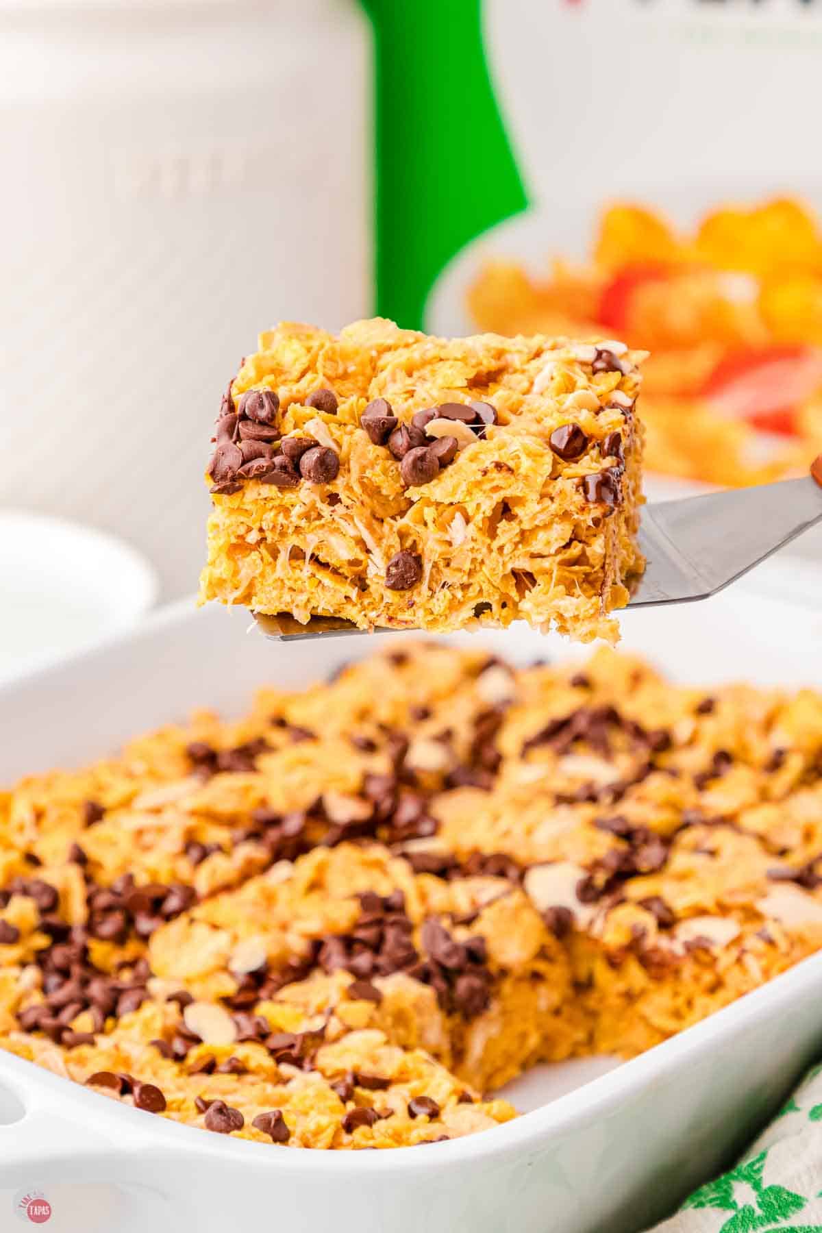 spatula holding a cornflake bar over a large dish