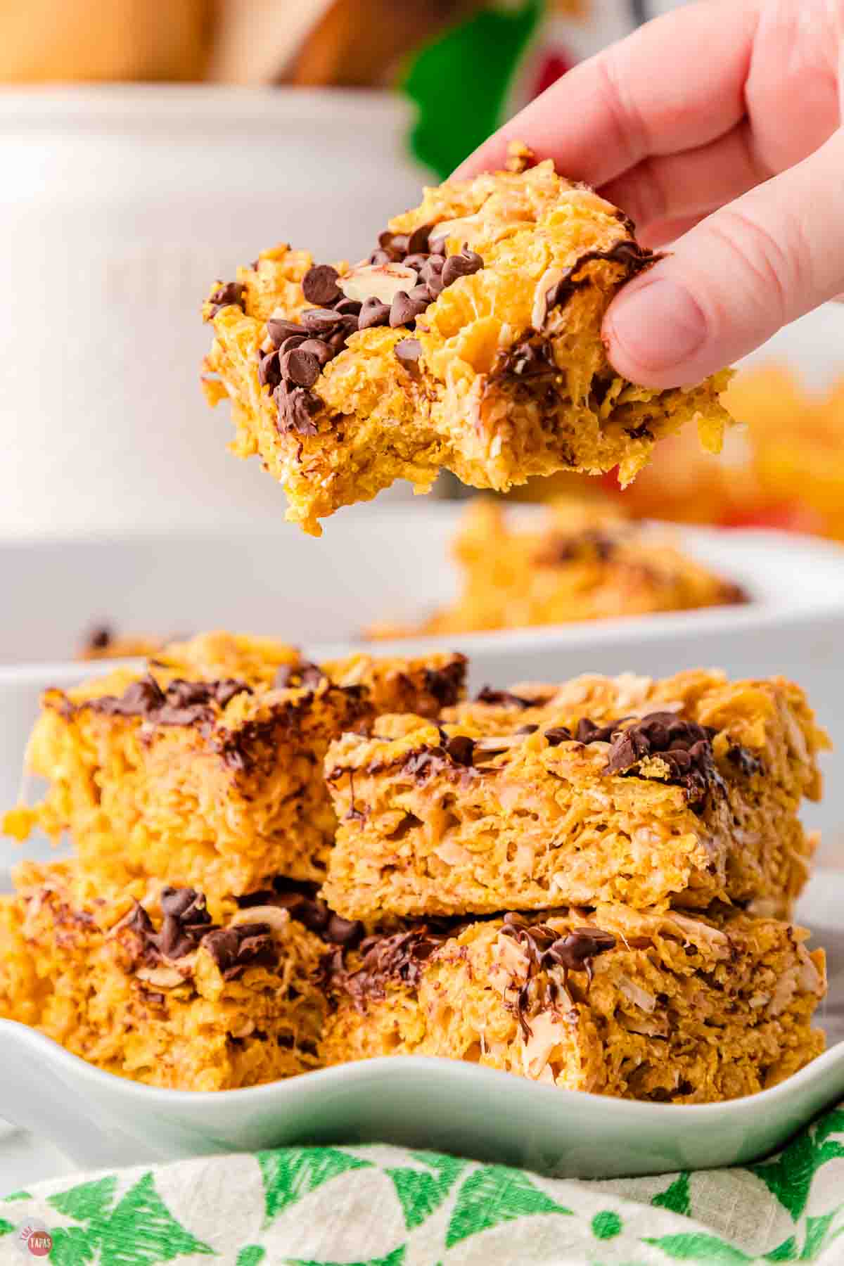 hand holding a cornflake bar with a bite missing