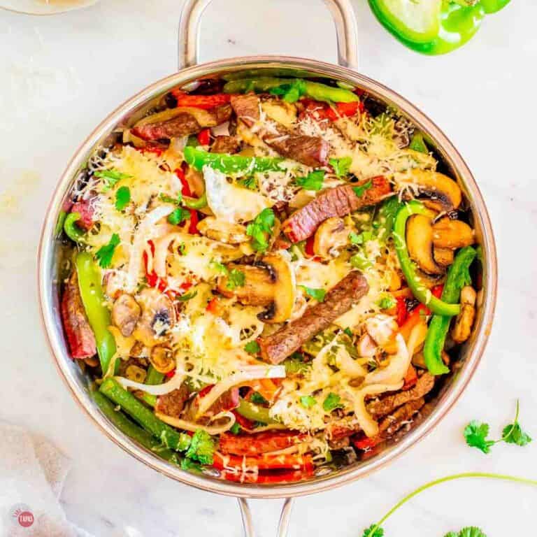 skillet full of philly cheesesteak ingredients