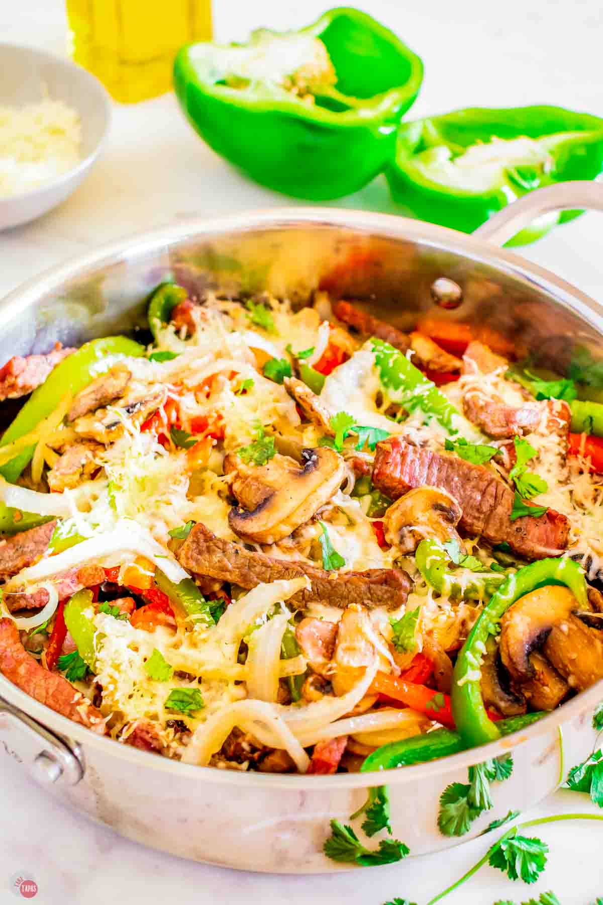 side view of skillet of Philly cheesesteak ingredients
