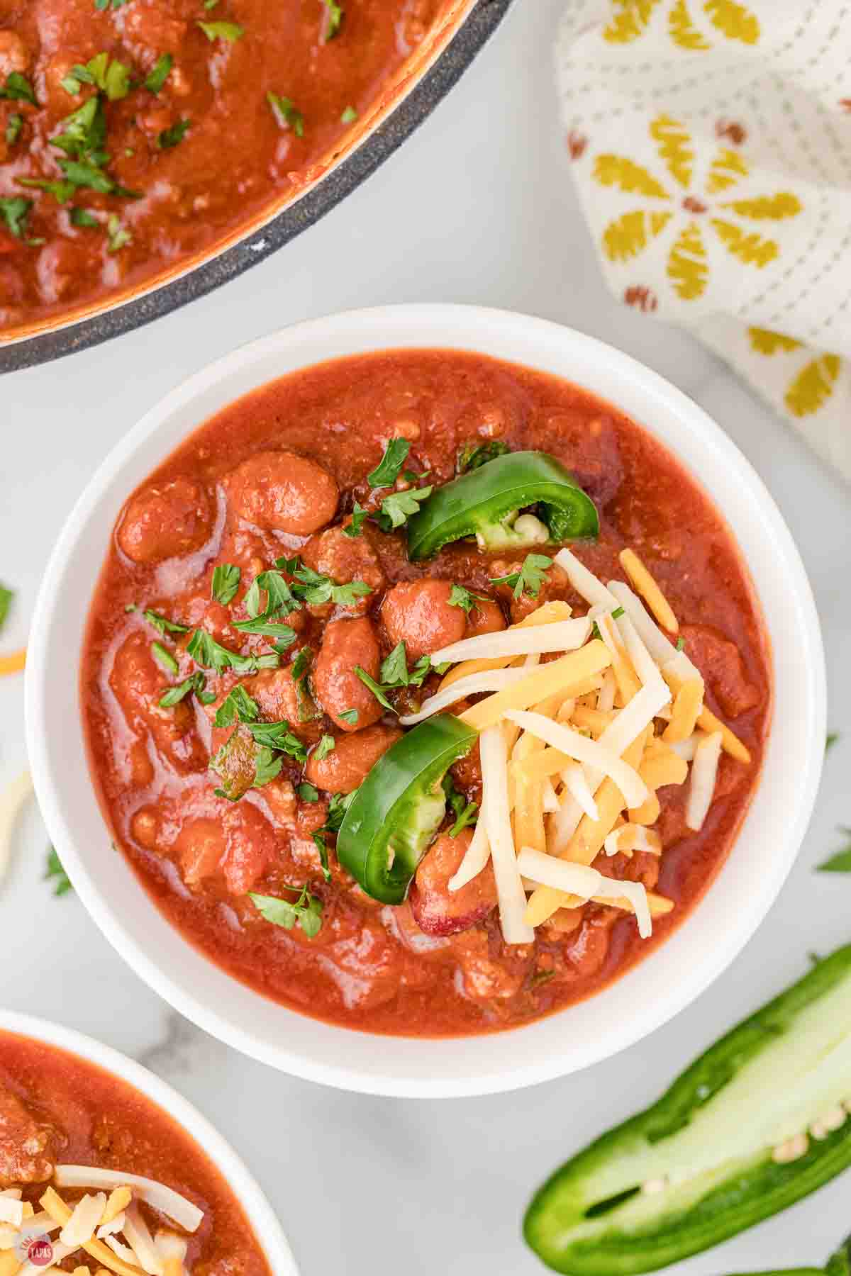 bowl of rotel chili topped with shredded cheese and jalapeno slices
