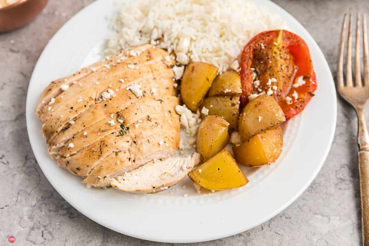 close up of chicken, rice, and tomatoes on a plate