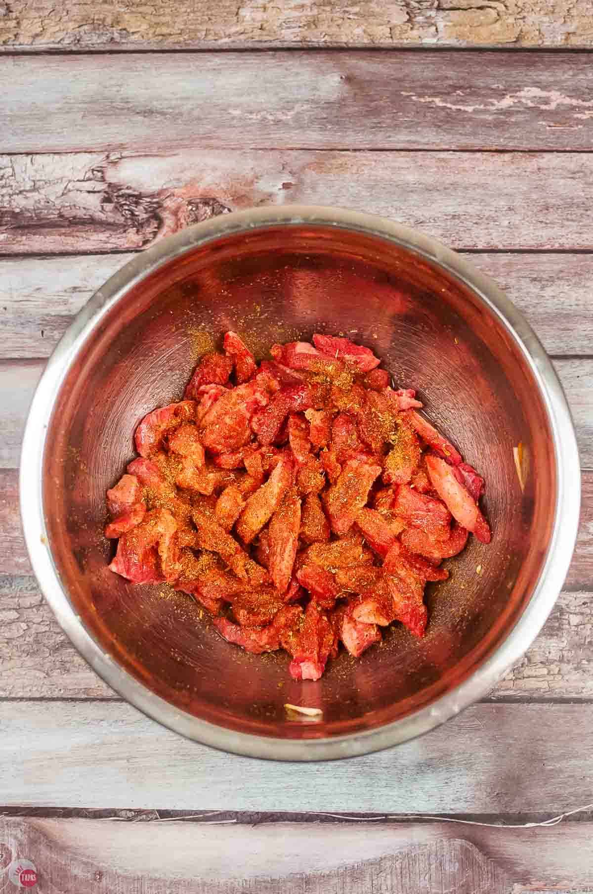 bowl of sliced flank steak with fajita seasoning on it