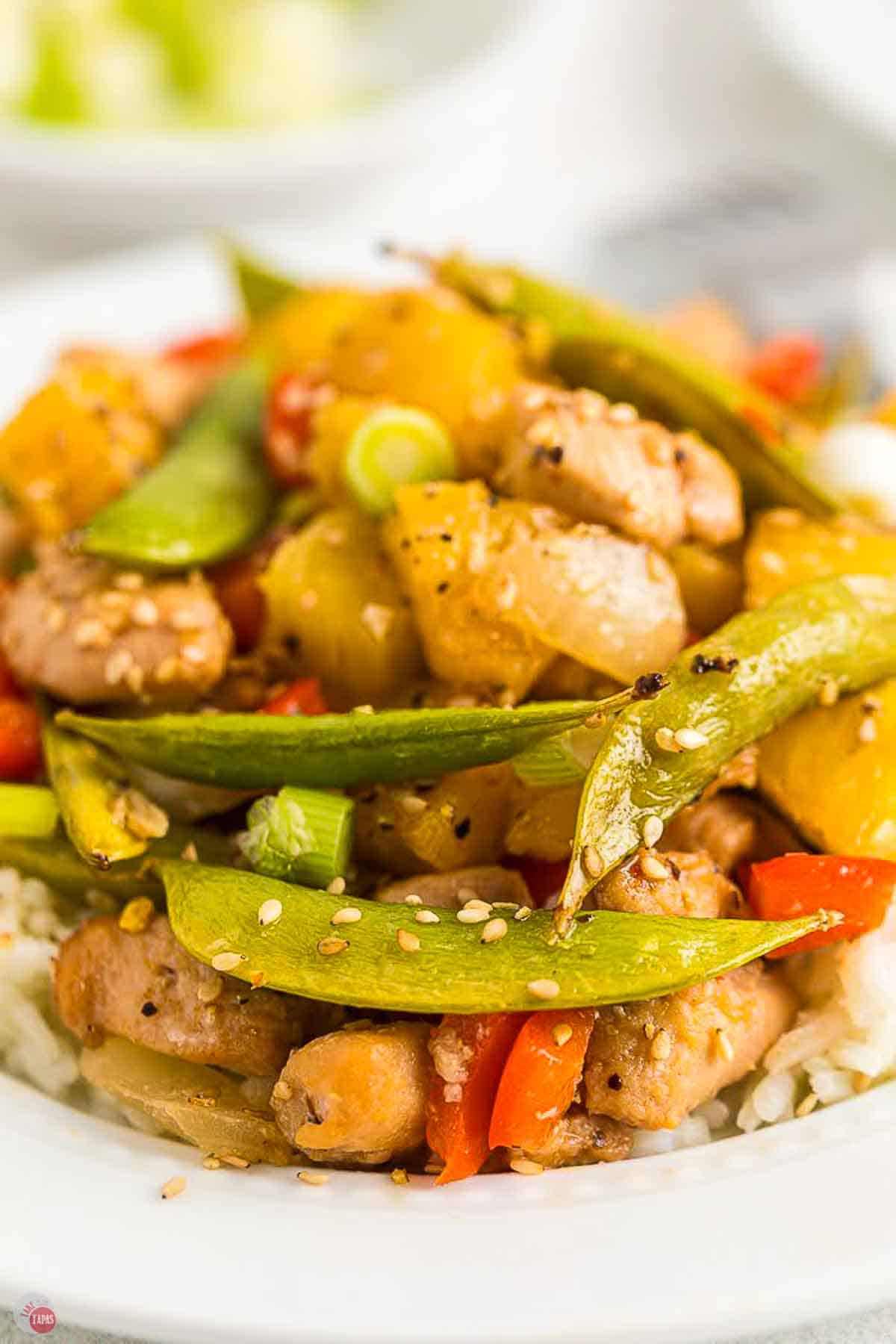 close up of chicken and vegetables topped with sesame seeds