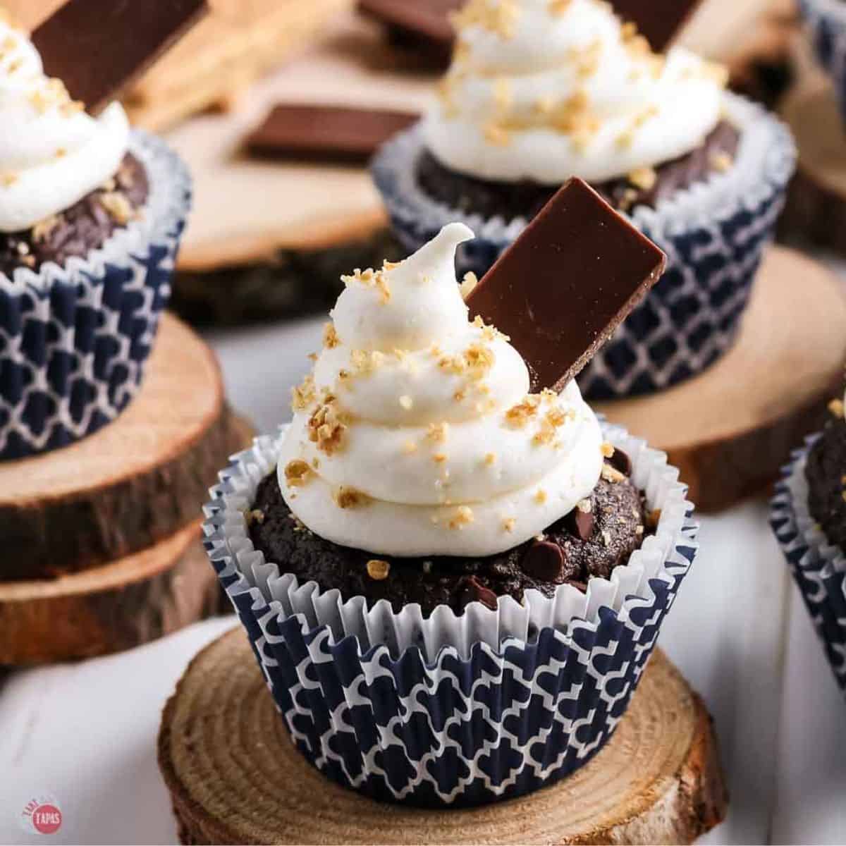 s'mores cupcake in a blue liner on a wood board