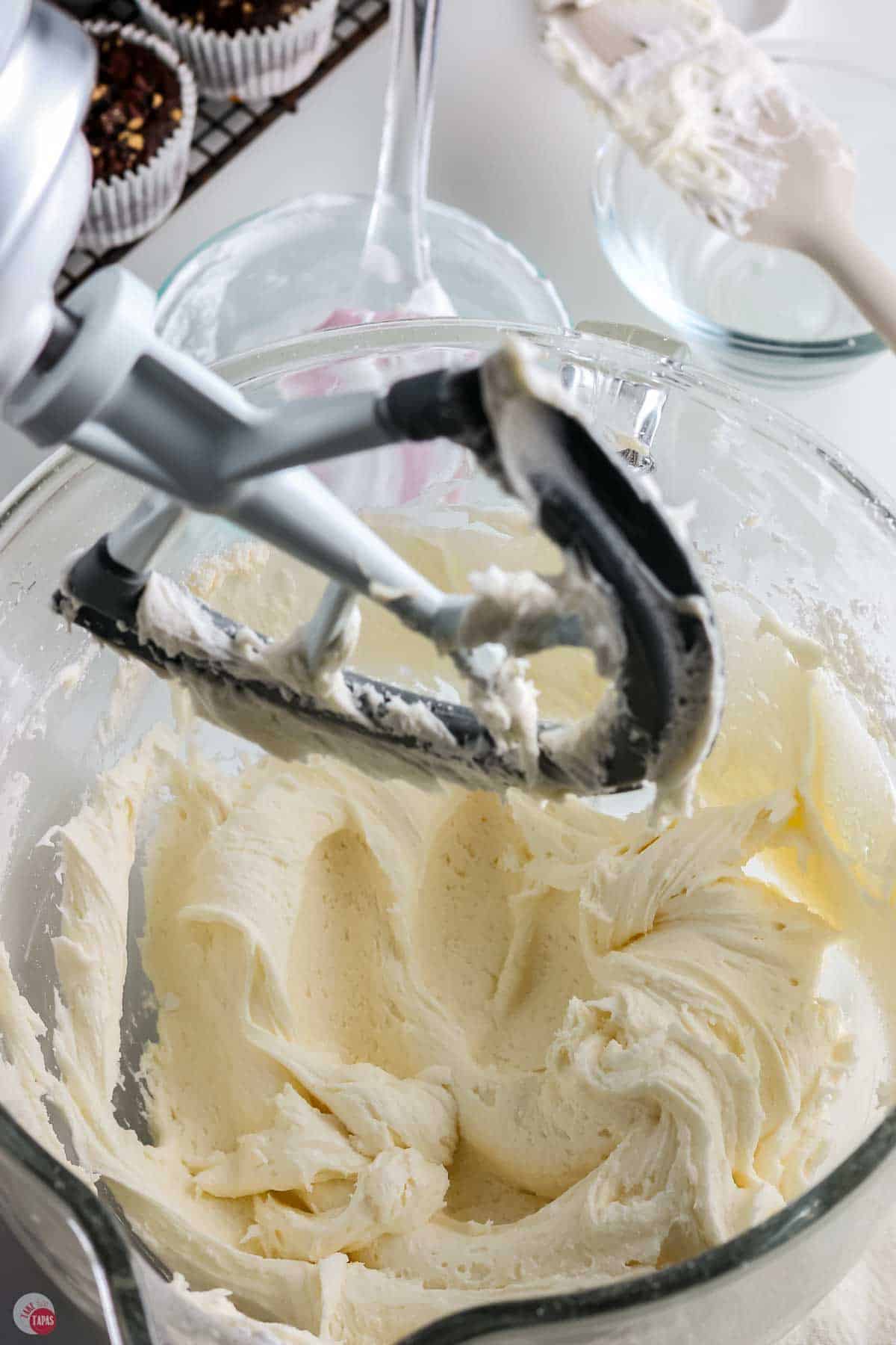 frosting being whipped in a mixing bowl