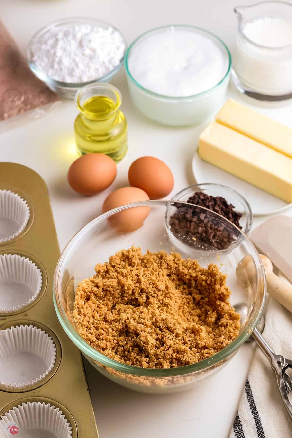 graham cracker crumbs mixed with butter in a clear bowl