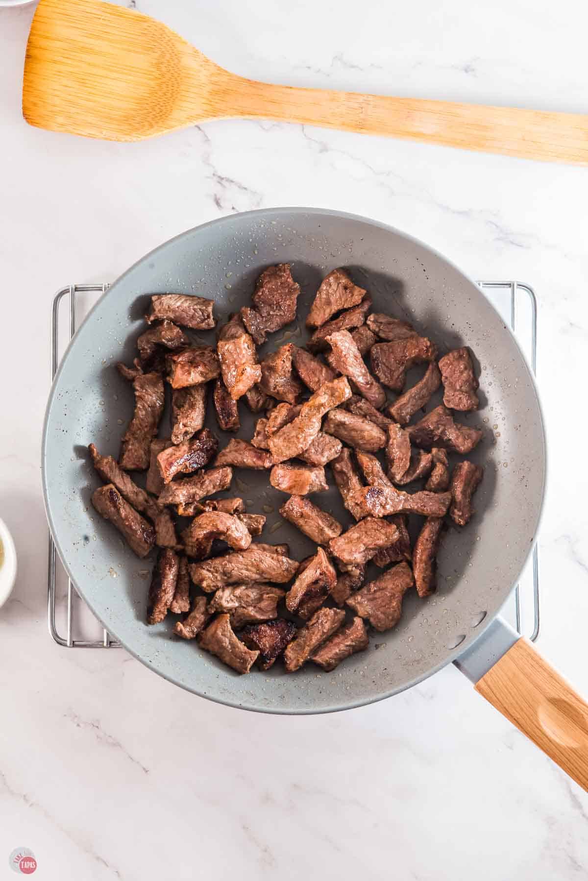 slices of steak cooking in a skillet