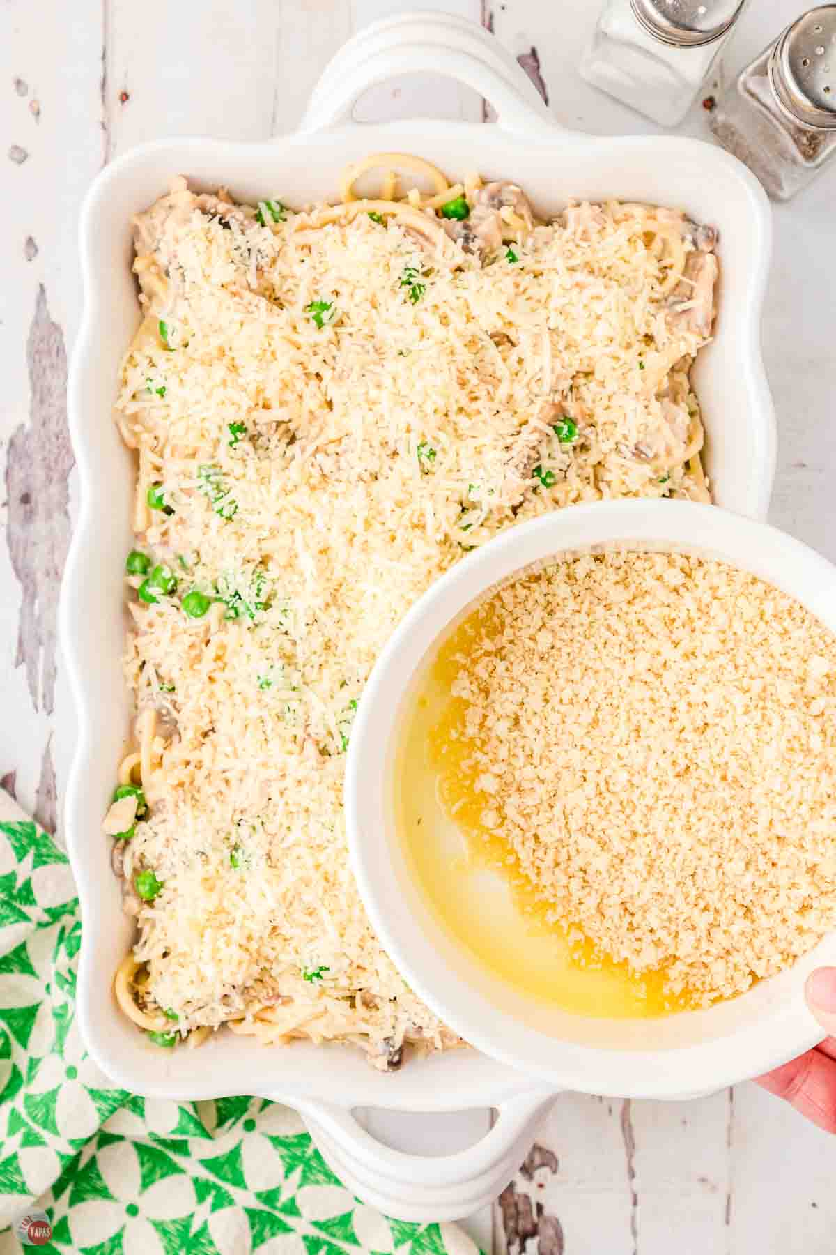 tuna tetrazzini casserole in a white dish with breadcrumbs and cheese bring sprinkled on top