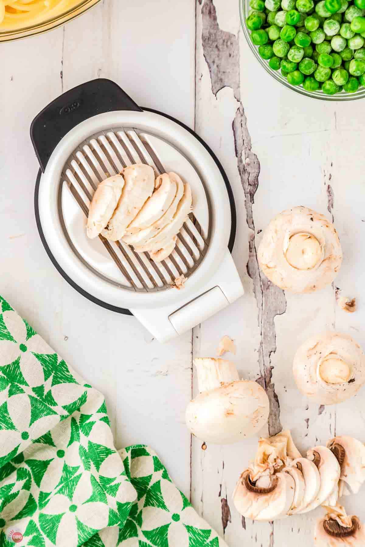 mushrooms being sliced in an egg slicer and a green napkin