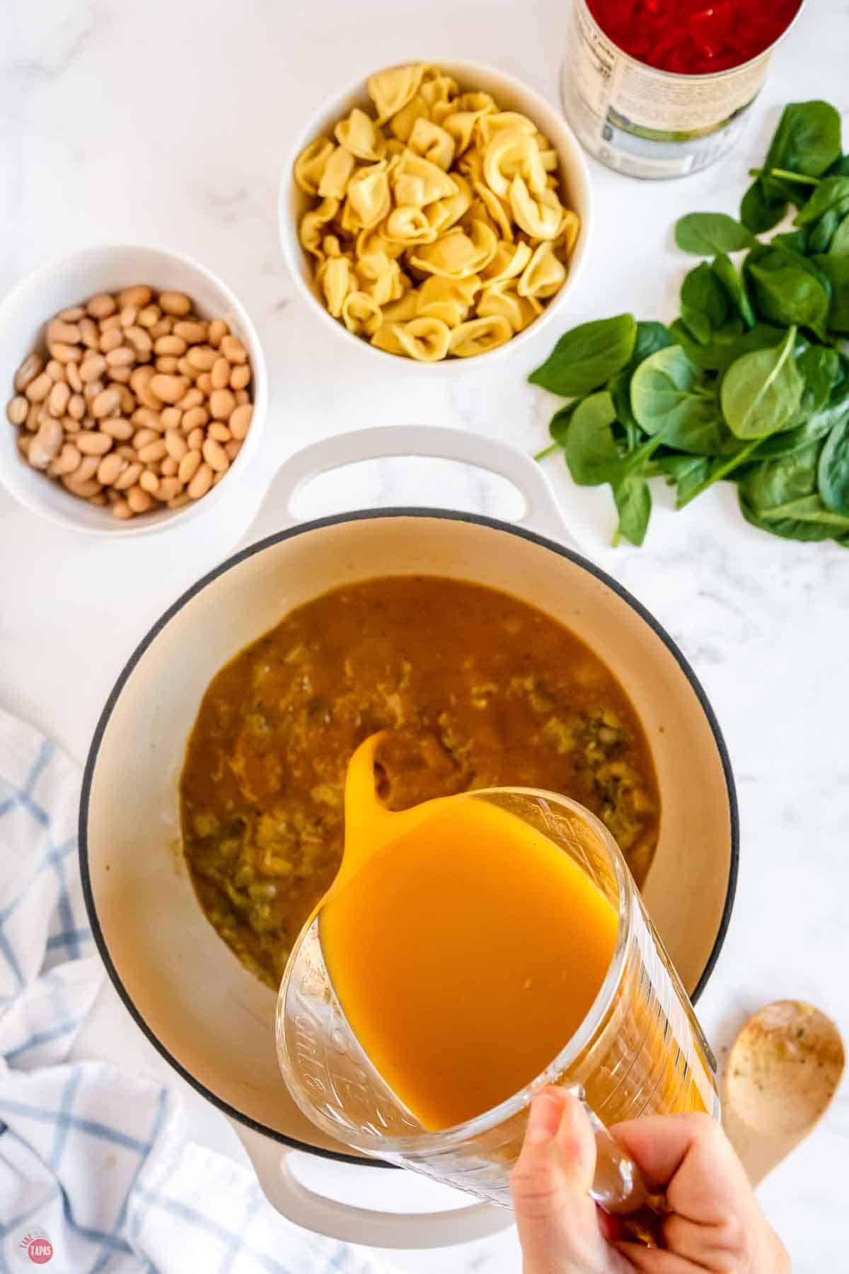 broth being poured into a soup pot