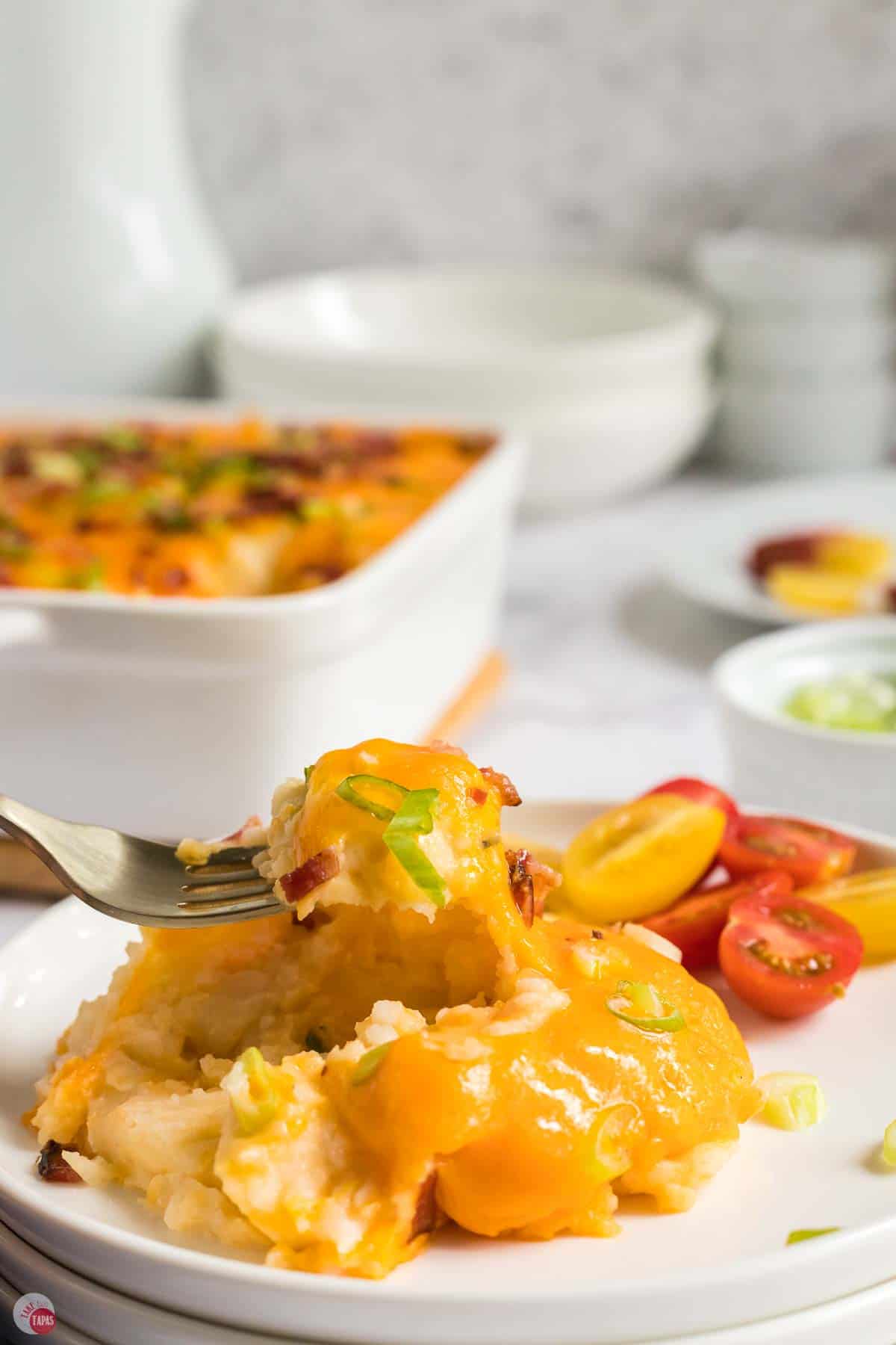 fork scooping up a bite of casserole with melted cheese